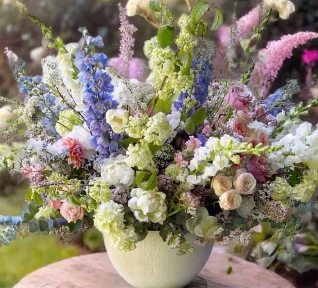 Mixed bouquet of pastel flowers in a white vase