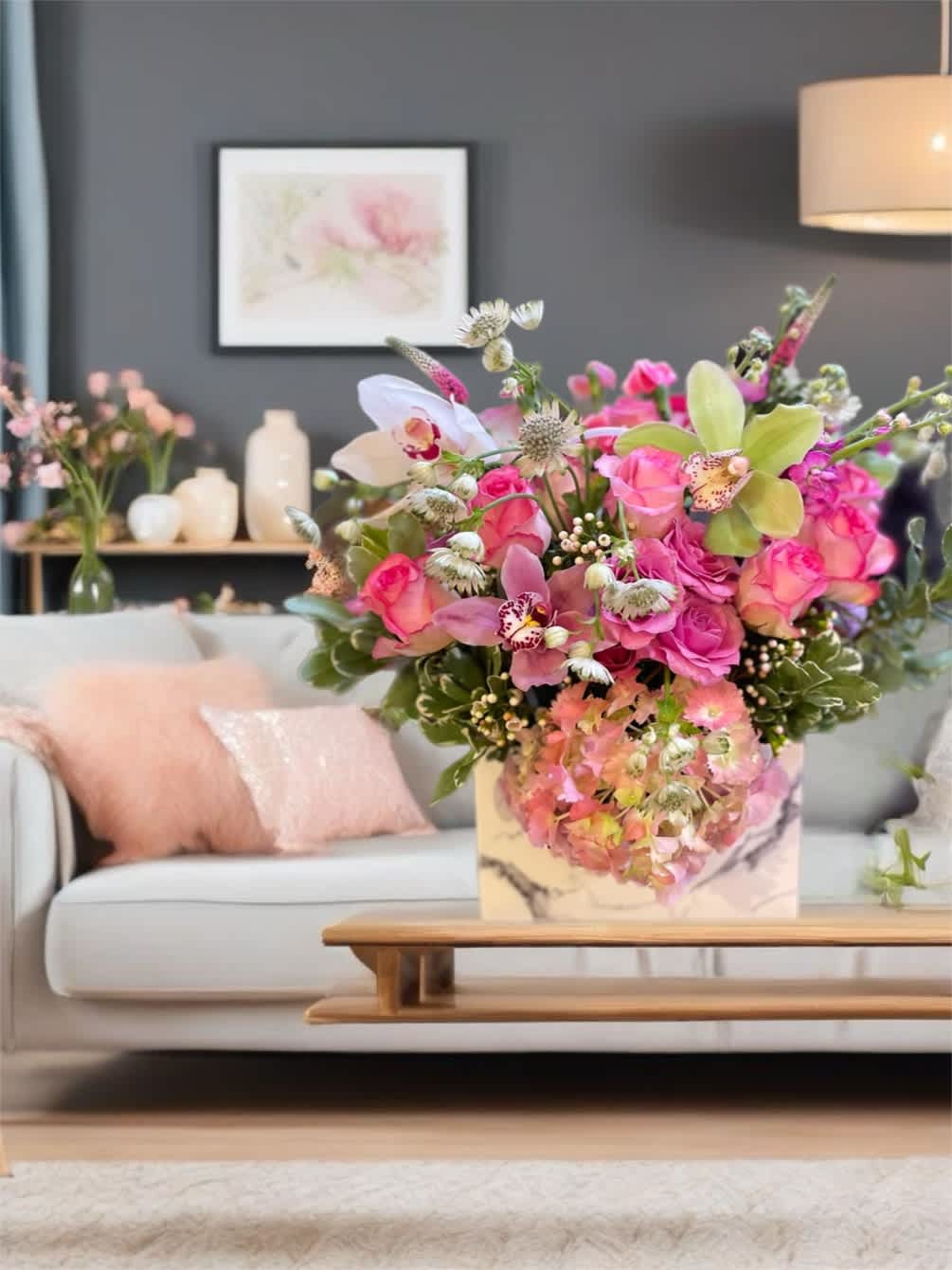 Pink and peach floral arrangement in a marble-patterned box