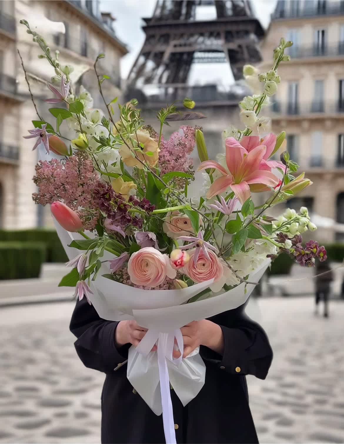 Hand-tied bouquet of pink and white flowers with a white wrap