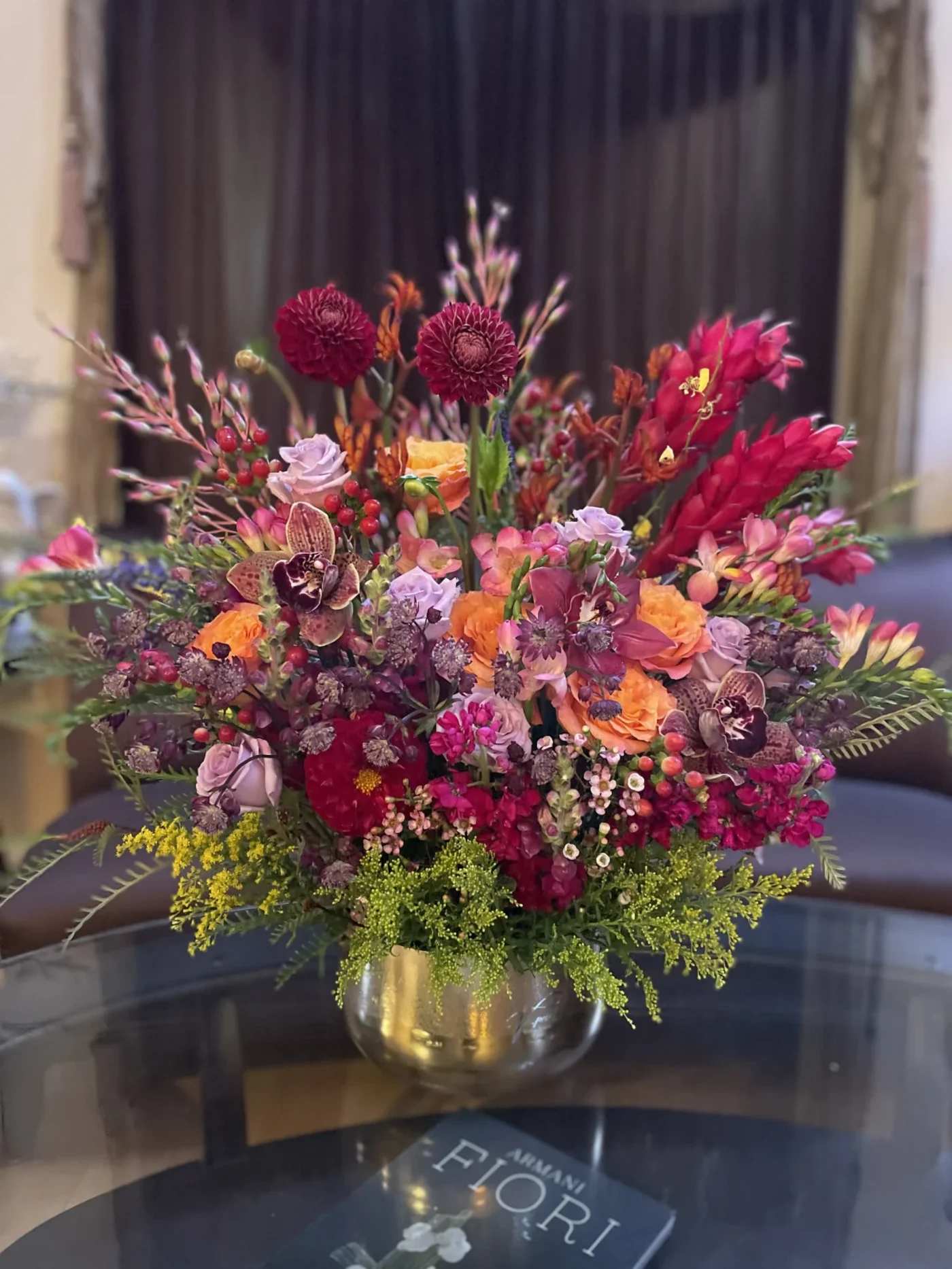 Colorful mixed flower arrangement in a gold vase