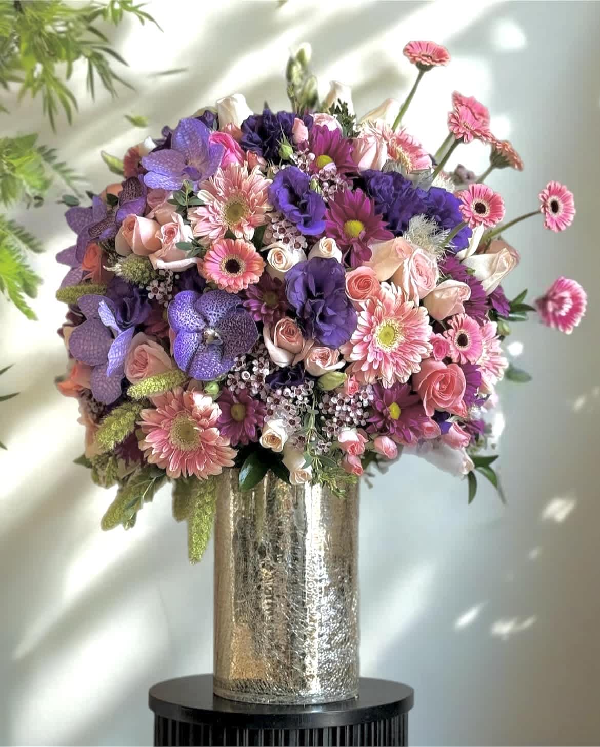 Large bouquet of pink, purple, and white flowers in a metallic vase