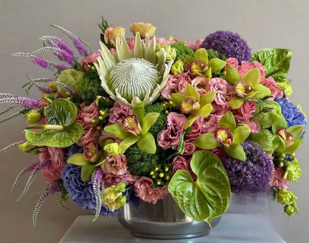 Colorful mixed floral arrangement in a silver bowl vase
