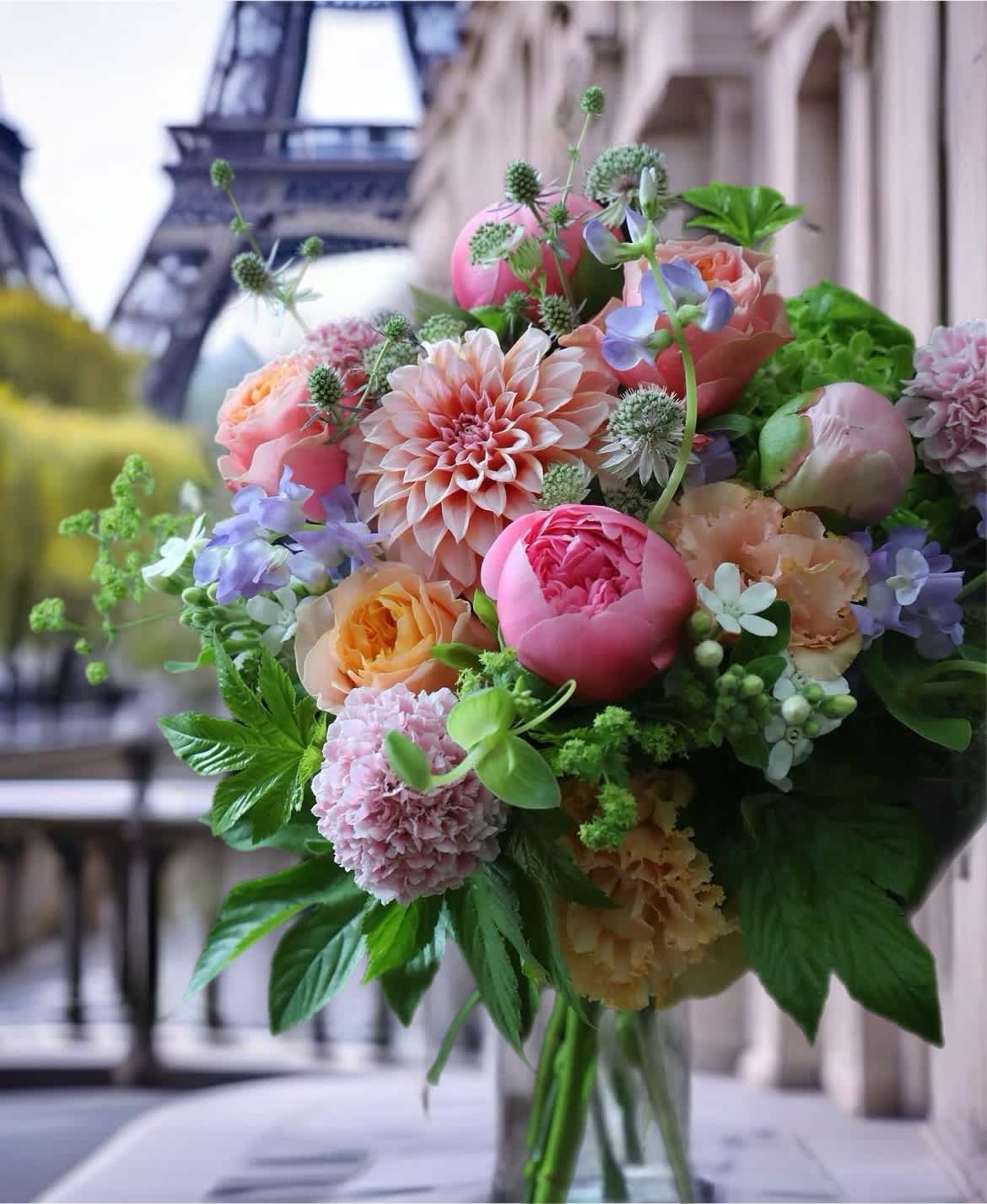 Bouquet of pink, peach, and lavender flowers with greenery