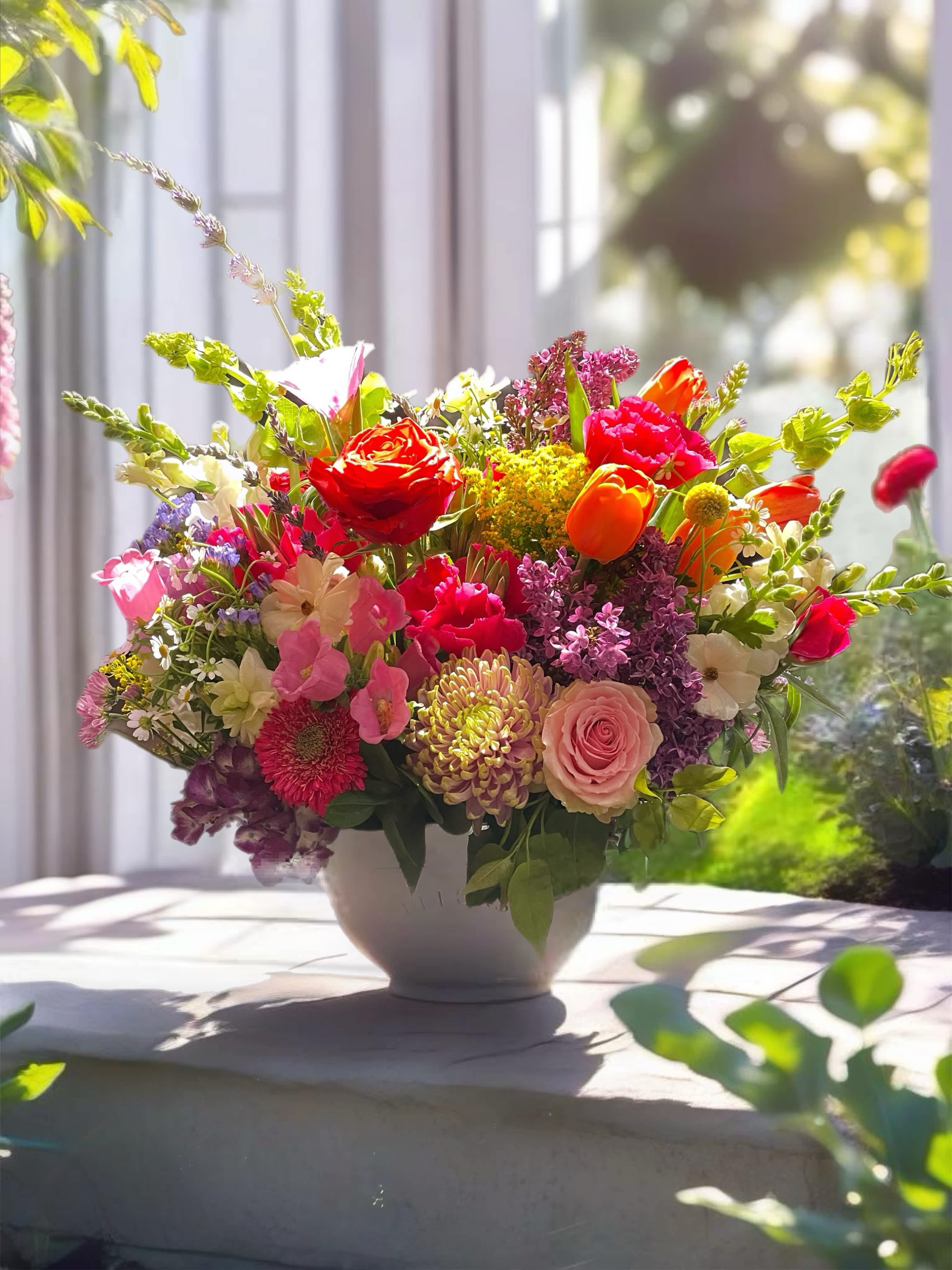 Colorful mixed flower arrangement in a white vase