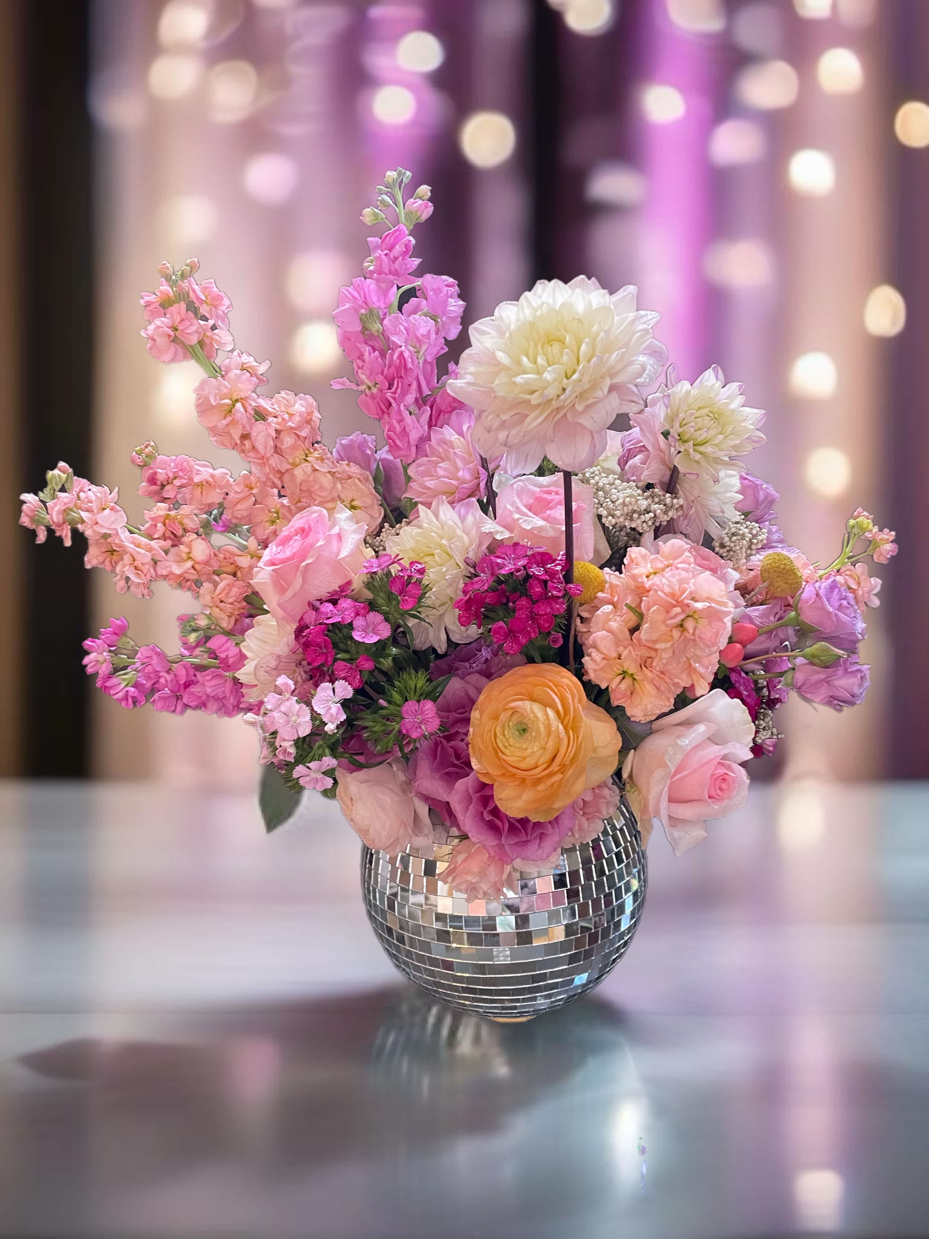Pink and white mixed flower arrangement in a mirrored vase