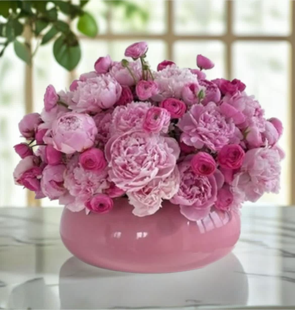 Pink floral arrangement in a round pink vase