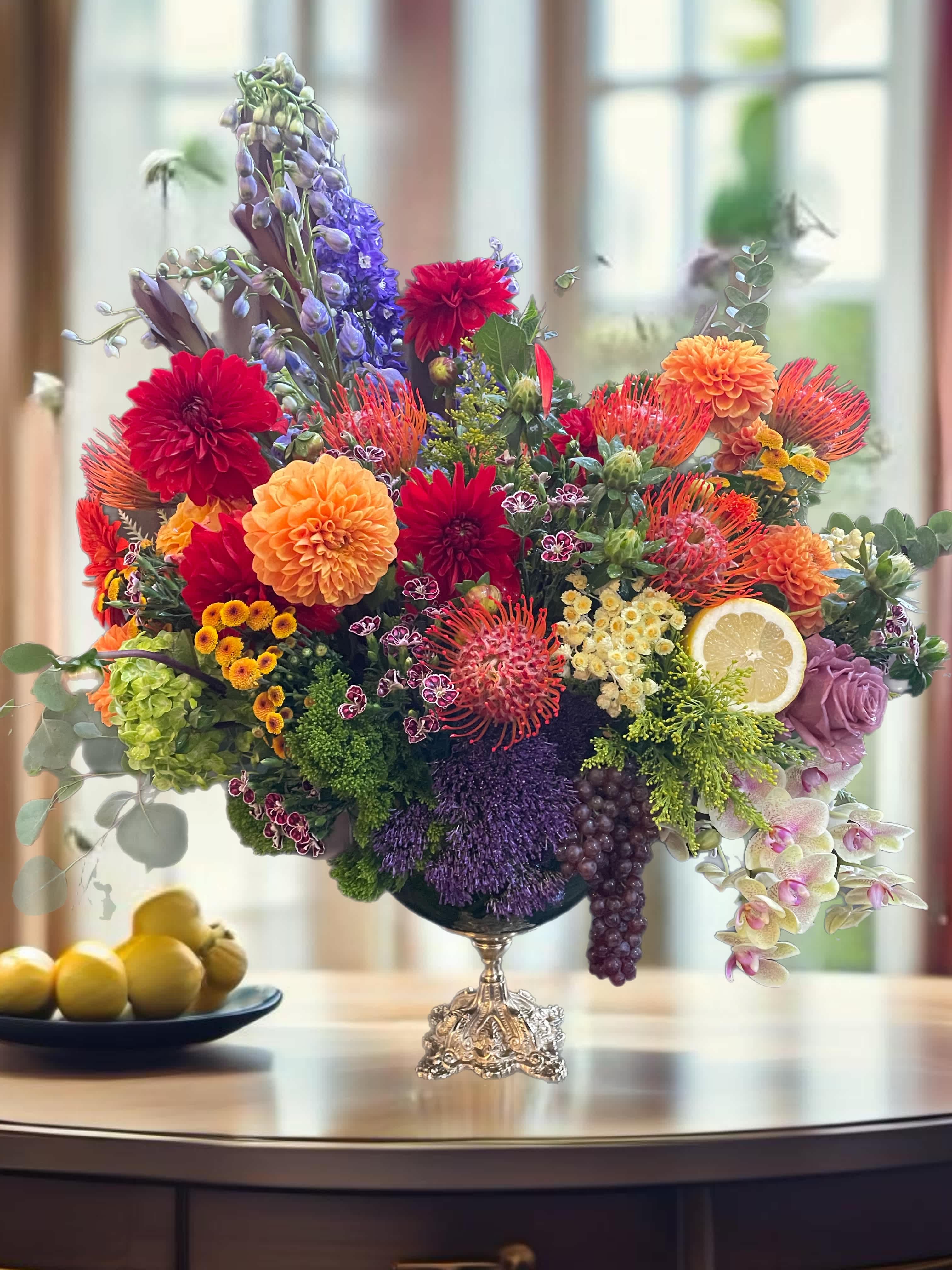 Colorful mixed flower arrangement in a silver pedestal vase
