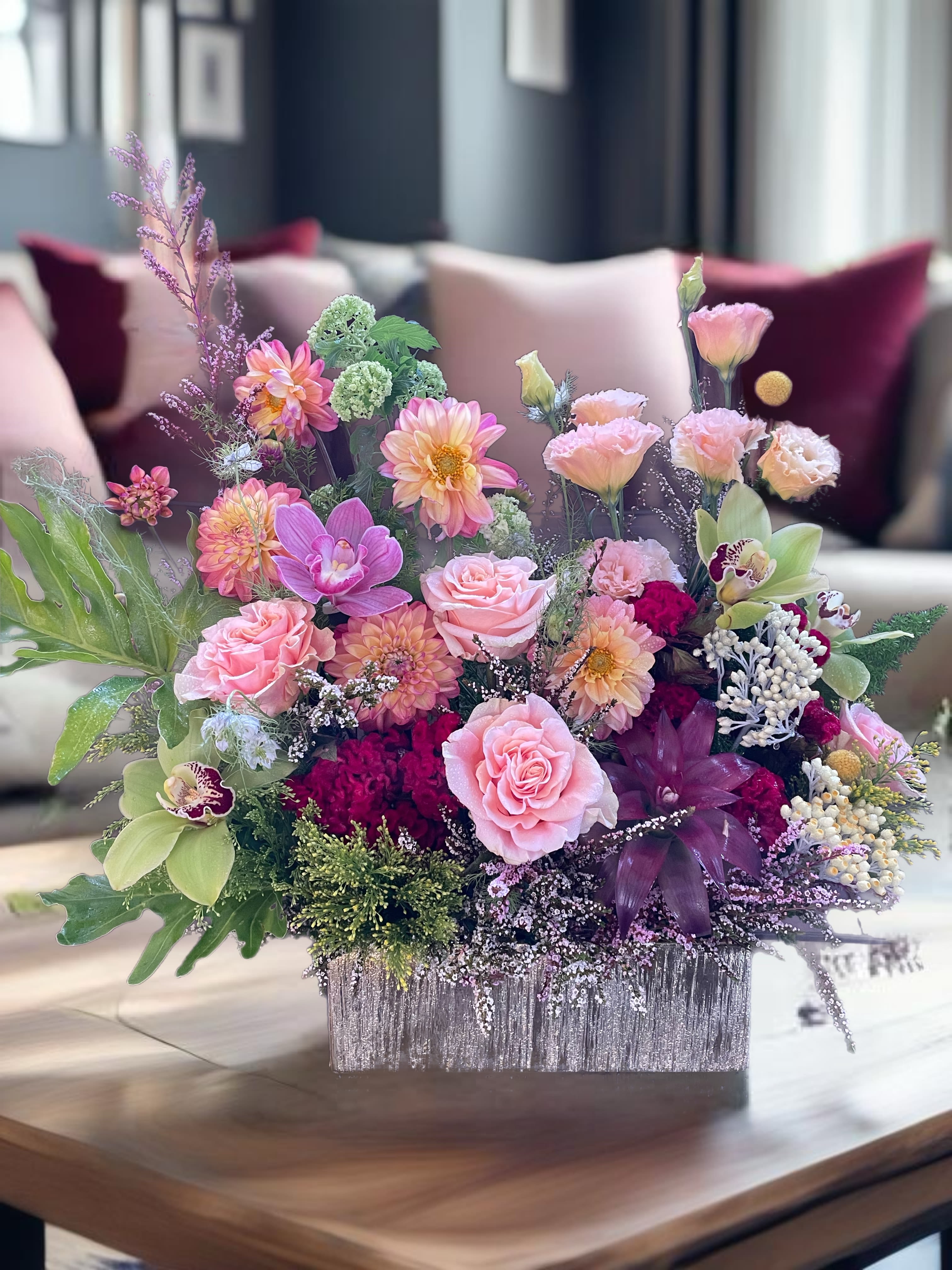 Pink and peach floral arrangement in a silver rectangular container