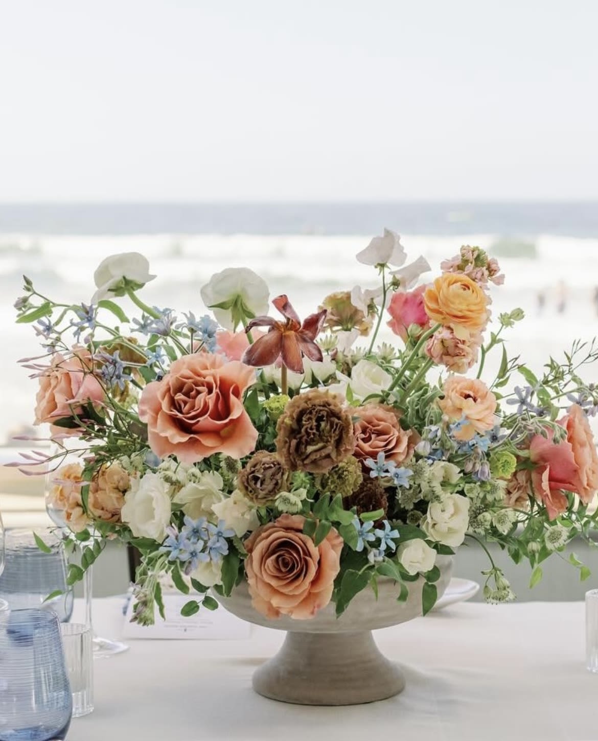 Peach and white floral centerpiece in a pedestal bowl