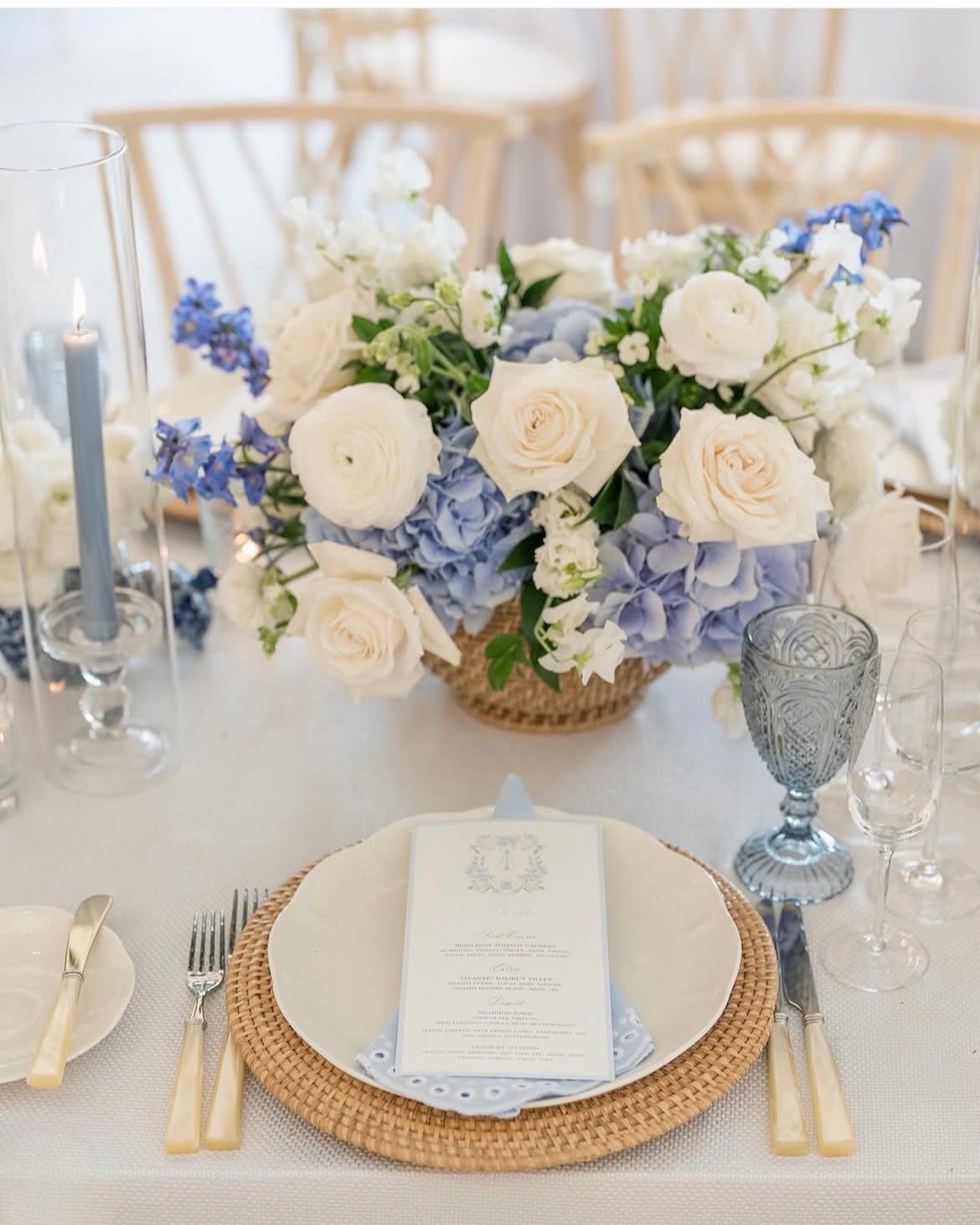 White and pale blue floral centerpiece on a table set for a formal event