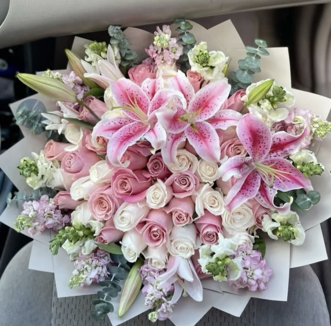Pink lilies and roses in a wrapped bouquet