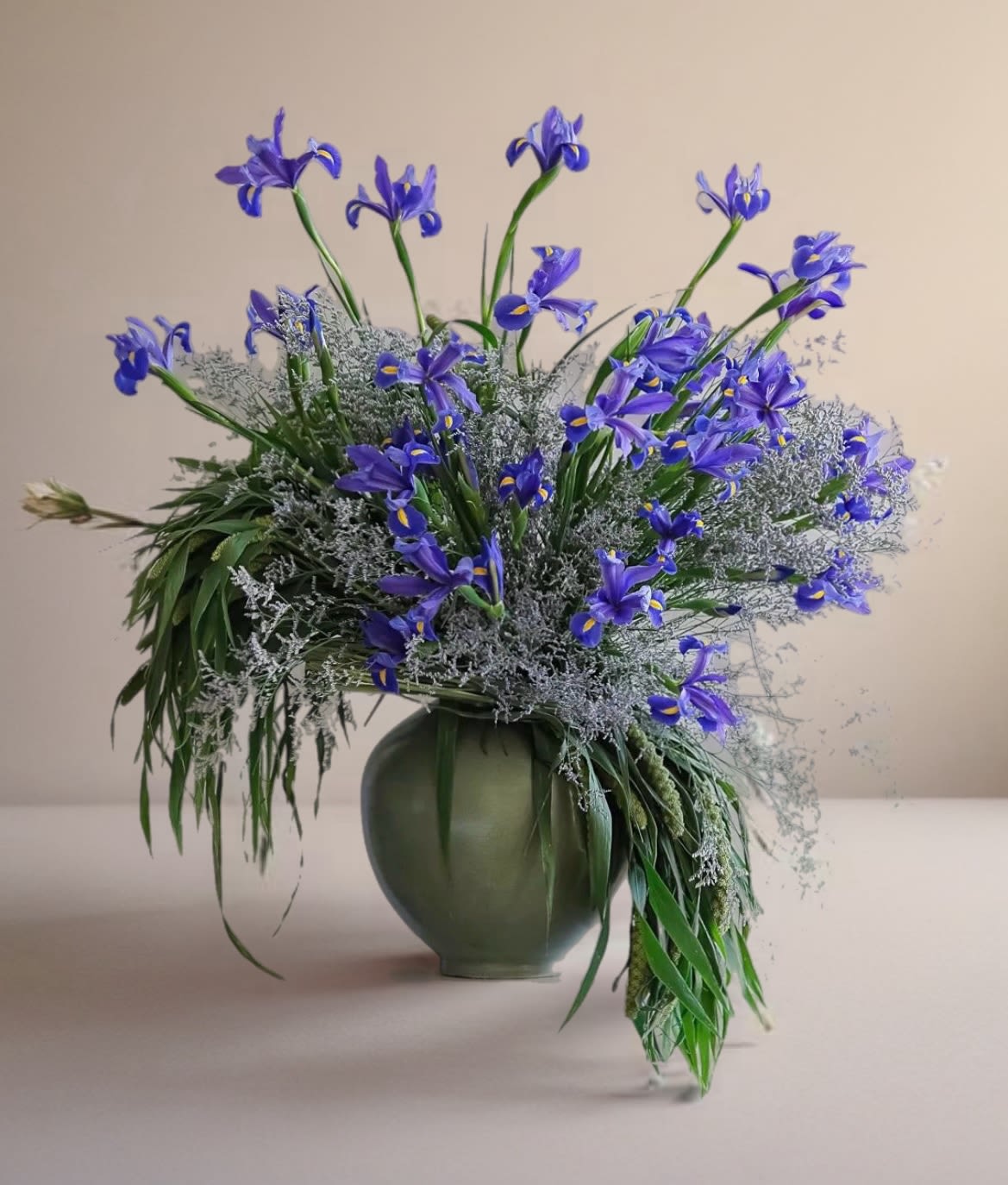Blue iris arrangement in a green vase