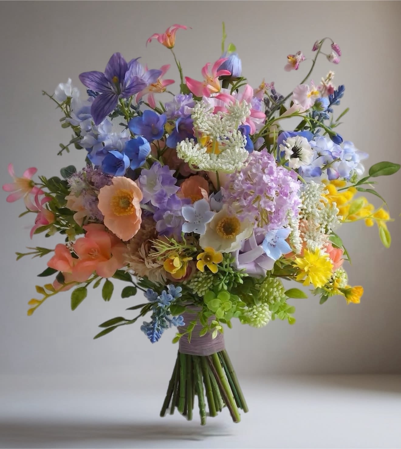 Colorful bouquet of mixed flowers in pink, blue, purple, and yellow