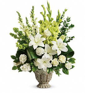 White lilies and green flowers arranged in a decorative urn