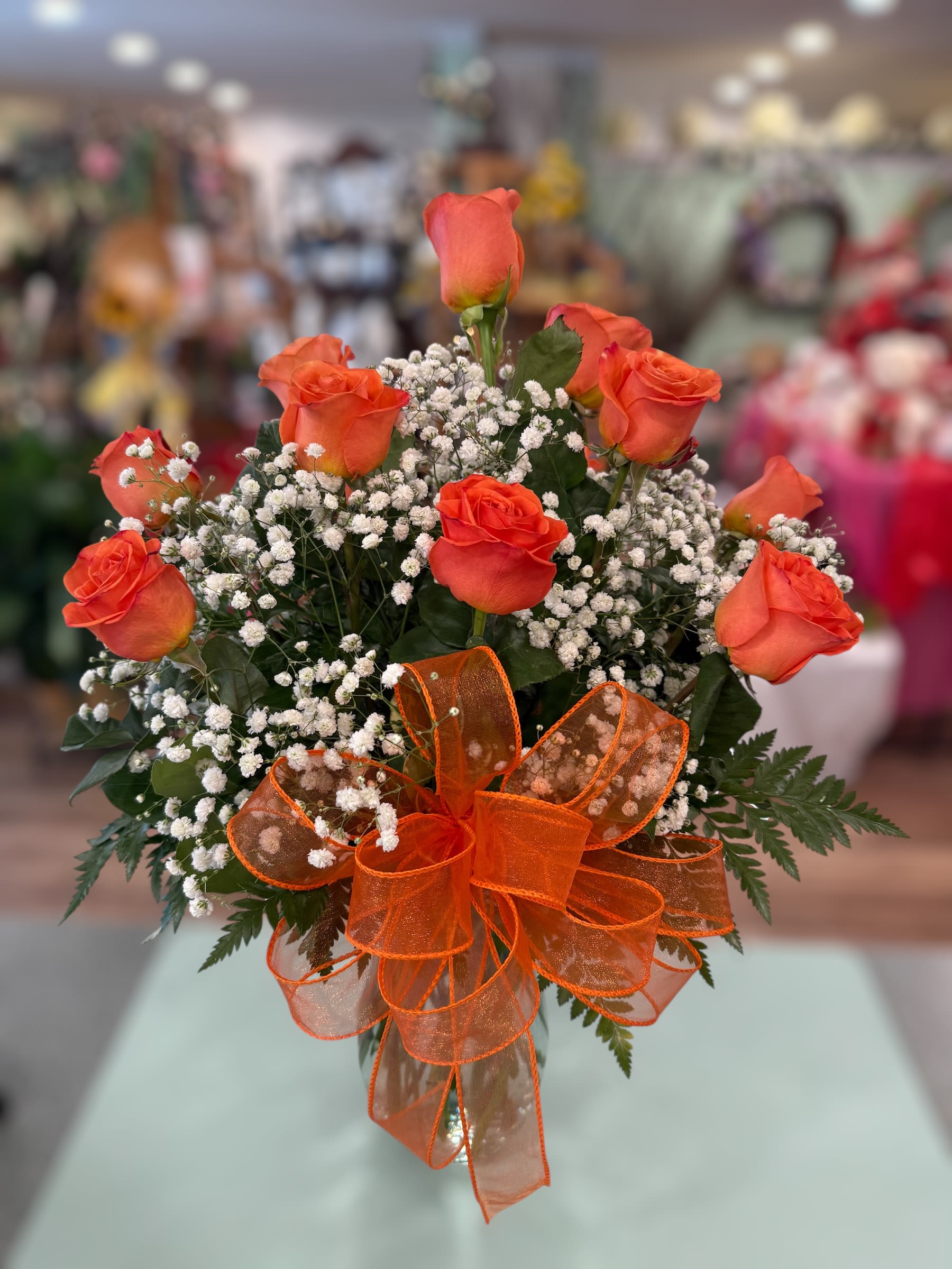 Orange roses with baby's breath and an orange ribbon bow