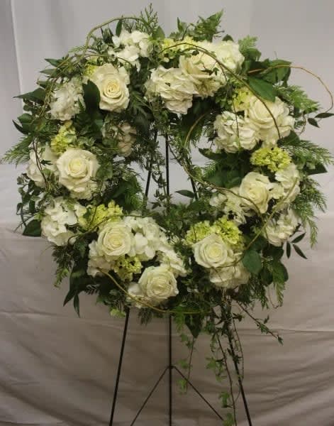 White rose and hydrangea wreath on a black stand