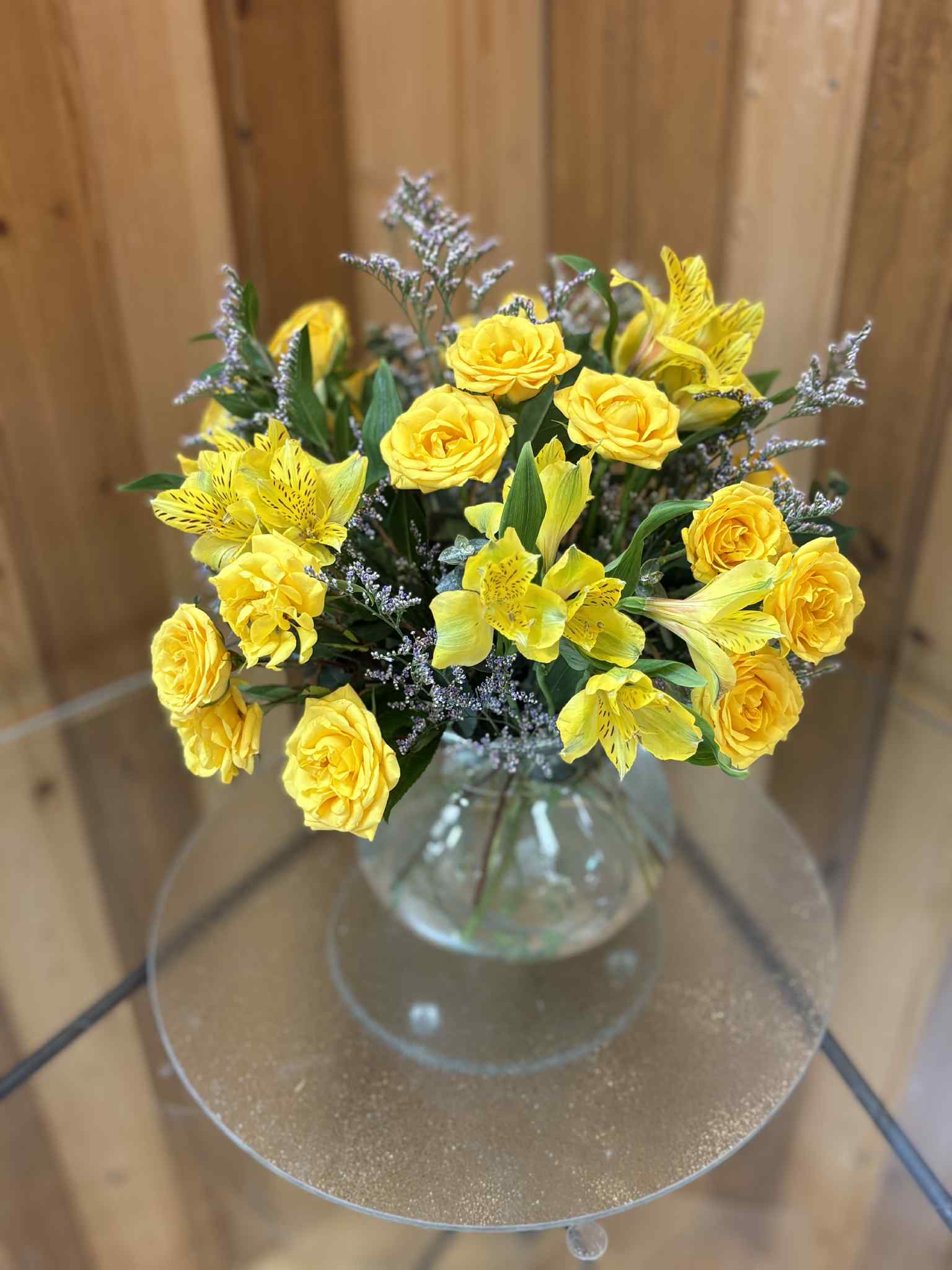 Yellow roses and alstroemeria in a clear glass vase