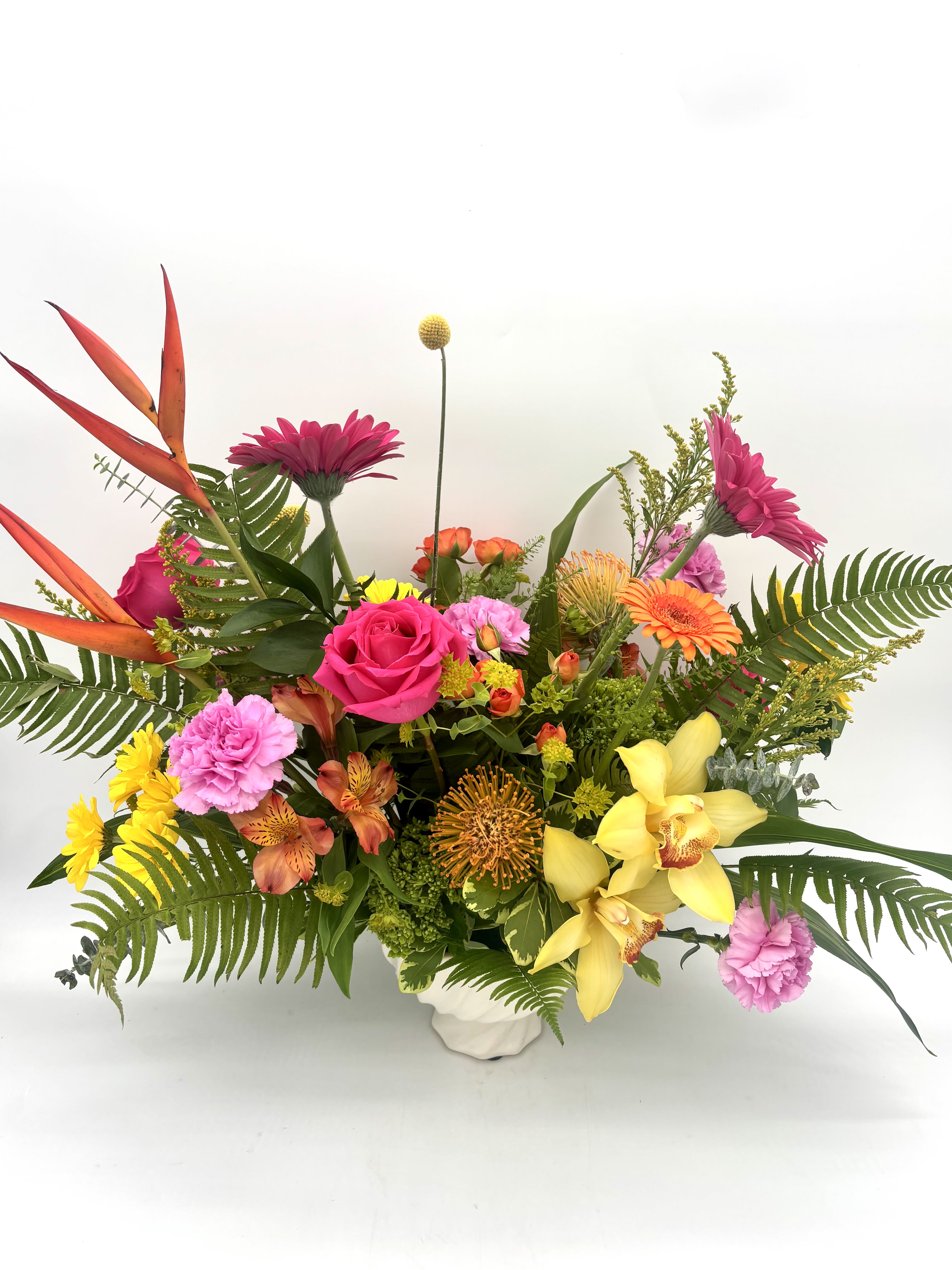 Island Tropic Centerpiecce - Escape to your own island paradise. Island Tropic is a lush, vibrant centerpiece bursting with bold tropical blooms, sun-soaked color, and breezy greenery that instantly transports you to warm ocean air and endless summer days. Designed to spark joy, it's a little escape you'll never want to leave.