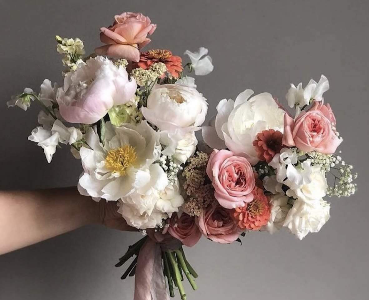 Hand-tied bouquet of pink and white flowers with a ribbon wrap