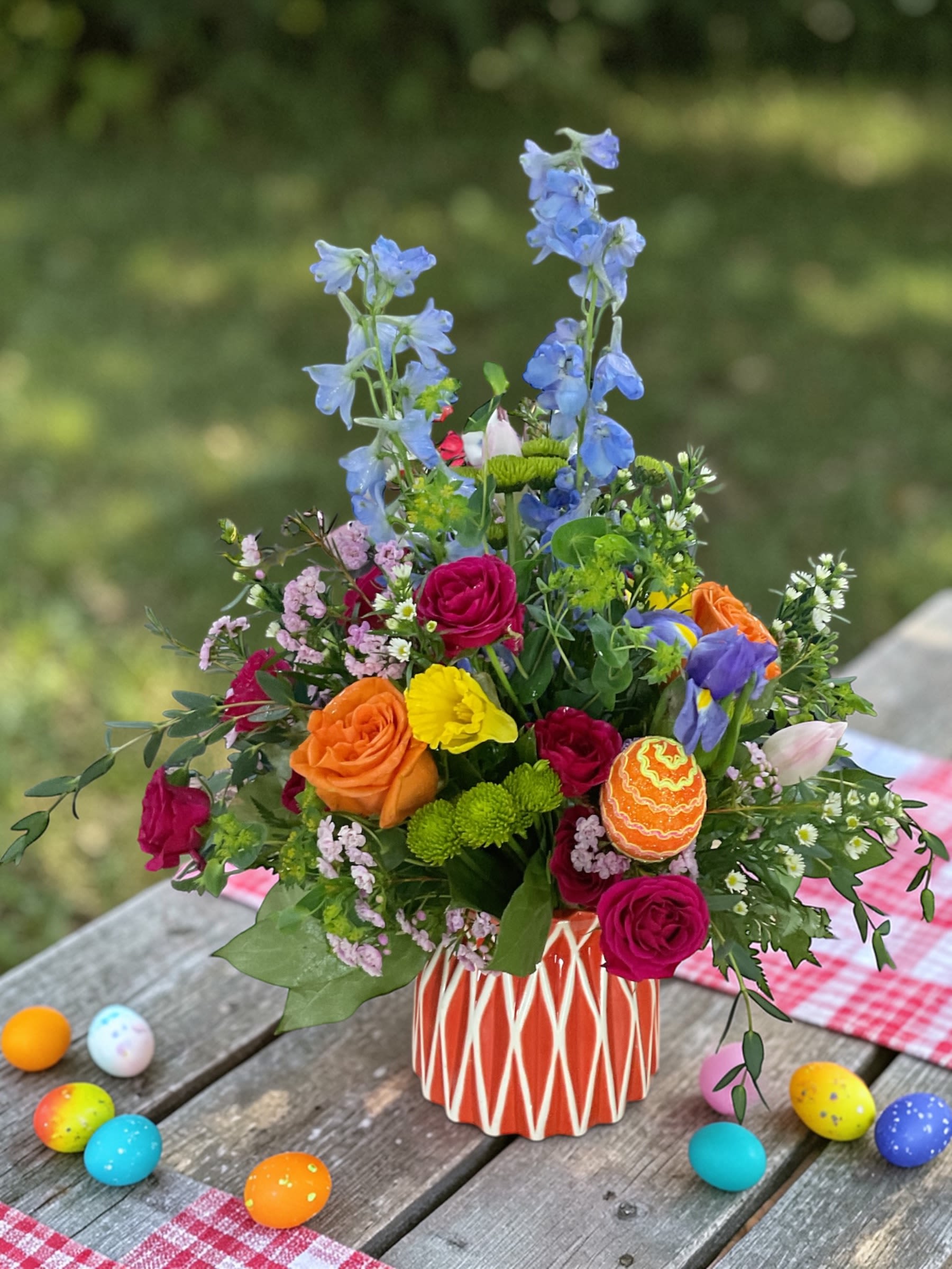 Egg Hunt Garden - Egg Hunt Garden is a bright and cheerful Easter centerpiece designed to celebrate the beauty of spring. This colorful arrangement features fresh seasonal flowers in soft pastels and vibrant tones, accented with playful Easter egg details for a festive, garden-inspired look.  Perfect for Easter gatherings, holiday tables, and seasonal gifting, this arrangement brings warmth, color, and a fresh spring feel into any home. Designed in a bold, eye-catching container, Egg Hunt Garden makes a statement while keeping the focus on lush blooms and natural texture.  Whether you’re sending Easter flowers to family, decorating your table, or surprising someone special, this Easter arrangement delivers both charm and impact. Each design is hand-crafted by a professional florist using the freshest available flowers to ensure quality, beauty, and long-lasting enjoyment.