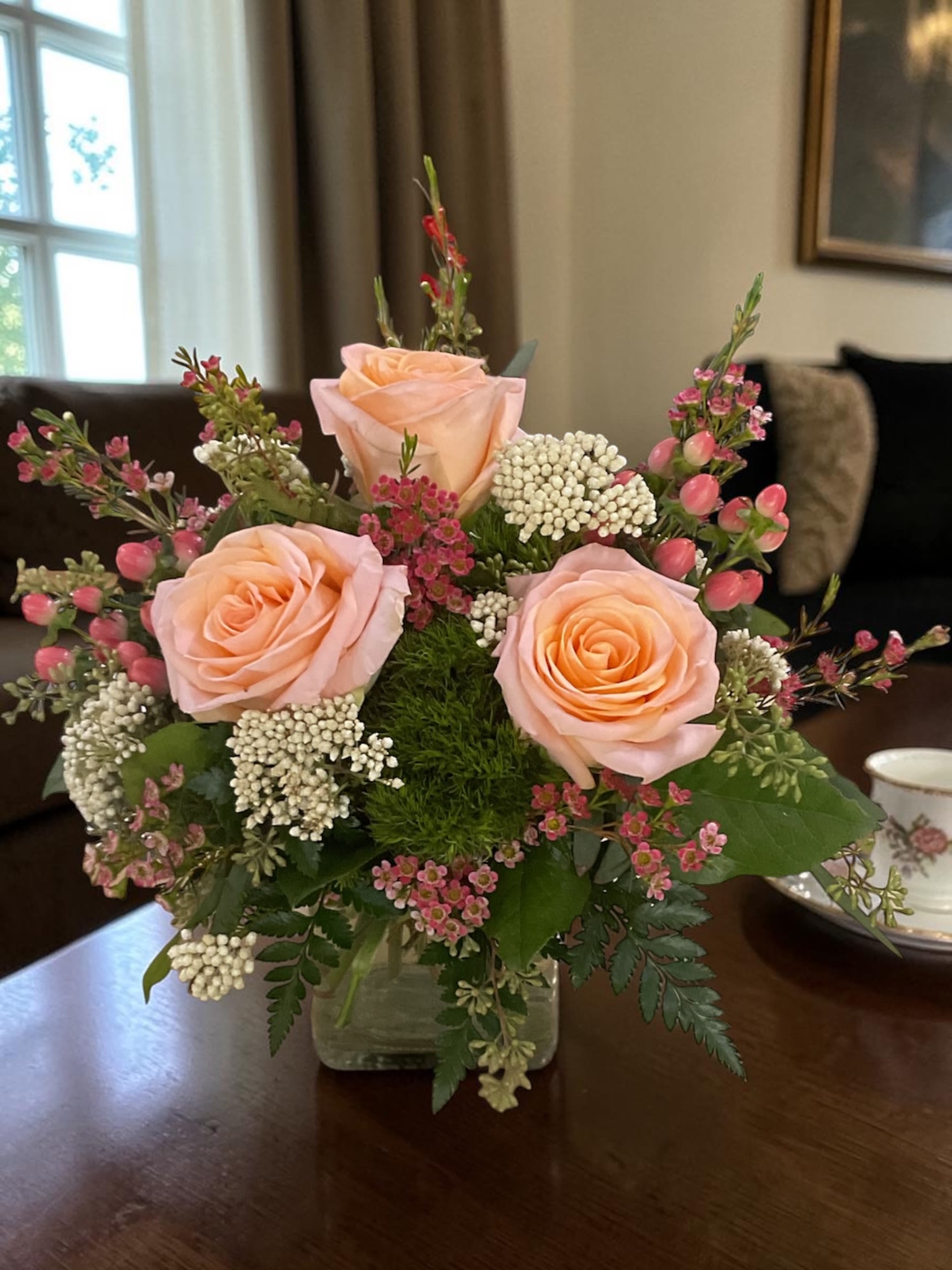 Peach Darling - Peach Darling is a fresh, garden-style floral arrangement built around soft peach Tiffany roses, pink hypericum, green trick dianthus, and white rice flower, finished with carefully selected seasonal accent blooms. Designed in a modern glass cube, each piece is structured for balance, movement, and a natural, airy feel.  This floral design blends warm peach tones with soft contrast and layered texture, creating a light, inviting look that works beautifully for everyday occasions. The combination of premium roses and textural elements adds depth without heaviness, giving it a clean, polished finish.  Hand-designed by a professional florist using standard premium flowers, Peach Darling is created for reliable flower delivery, maintaining its shape, freshness, and overall appearance beyond arrival. It’s an elevated choice for everyday floral delivery, offering consistent quality and thoughtful design in every arrangement.