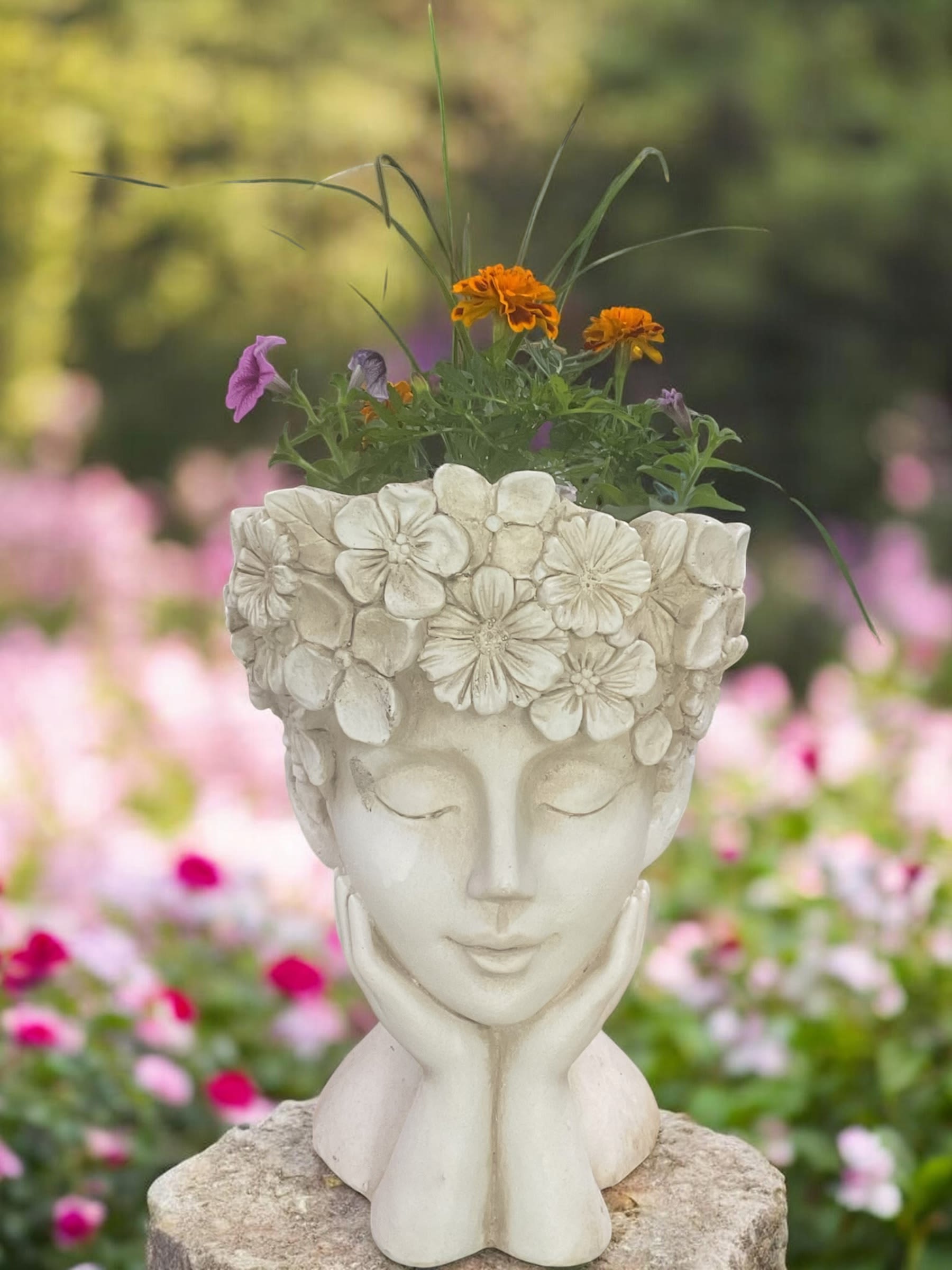Goddess of the Garden - Add personality and garden charm to any outdoor space with our Goddess of the Garden planter from Aspen Tower Florist. This eye-catching decorative face planter is designed with seasonal blooming plants and textured greenery for a whimsical, artistic look that stands out on porches, patios, entryways, decks, balconies, garden beds, and outdoor seating areas.  Featuring a sculpted floral goddess container filled with colorful seasonal plants, this living garden arrangement makes a thoughtful gift for birthdays, housewarmings, retirement gifts, thank you gifts, garden lovers, plant enthusiasts, or just because. Its artistic design blends flowers, greenery, and garden décor into one beautiful display that continues to grow and change throughout the season.  Plant varieties and colors may vary based on seasonal availability, weather, and growing conditions. Additional images may include AI simulated growth examples to help visualize how the planter can fill in later in the season.  Aspen Tower Florist proudly offers local delivery in Greensburg, Indiana and surrounding communities including Batesville, Shelbyville, Rushville, Hope, Westport, North Vernon, and nearby areas. We also deliver to homes, businesses, care facilities, and local funeral homes.  Order direct from Aspen Tower Florist for handcrafted plant gifts, personalized service, and dependable local delivery.
