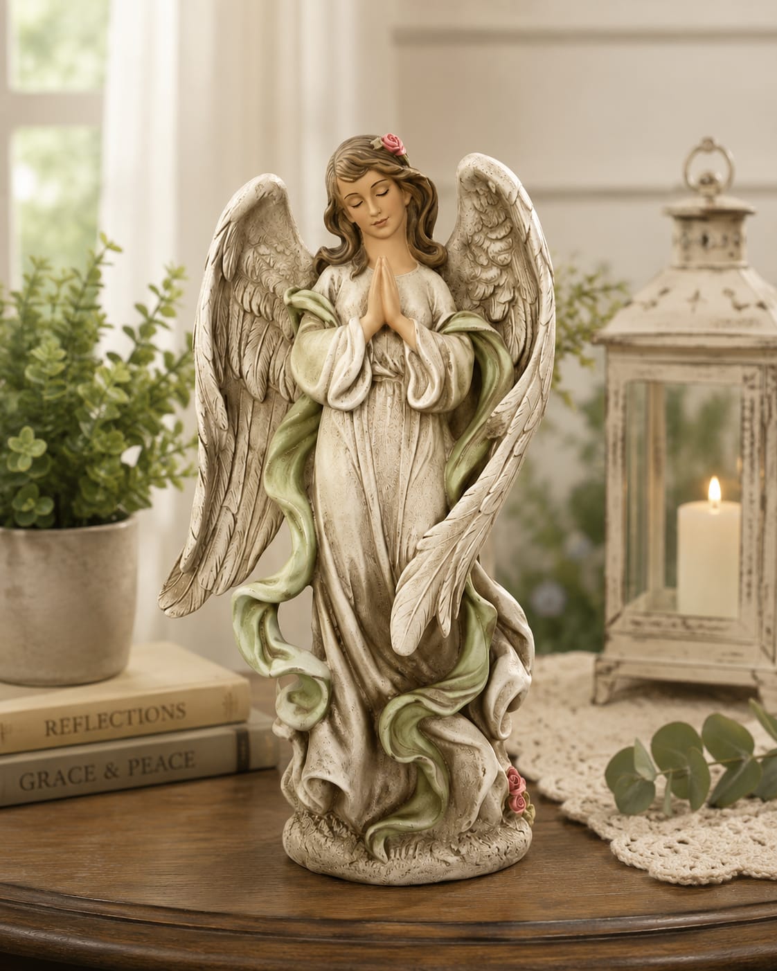 11” Praying Angel - A beautiful angel never goes out of style.  For generations, angels have represented faith, comfort, protection, hope, and the belief that we are never truly alone. This graceful praying angel captures that timeless message in a design that is both elegant and meaningful.  With delicate wings, flowing robes, and hands folded in prayer, she brings a sense of peace and inspiration wherever she is displayed. Whether placed on a mantel, bookshelf, entry table, office desk, or bedside stand, this angel adds warmth, beauty, and purpose to any space.  Unlike flowers that brighten a room for a few days, this keepsake becomes part of a home. A quiet reminder of faith. A symbol of love. A gift that continues to bring comfort and encouragement long after the occasion has passed.  Available on its own, accented with a fresh floral arrangement, or surrounded by an abundant premium floral display, this praying angel is a thoughtful choice for celebrations, expressions of faith, encouragement, remembrance, memorial tributes, and sympathy.  Beautiful today. Meaningful tomorrow. Treasured for years to come.