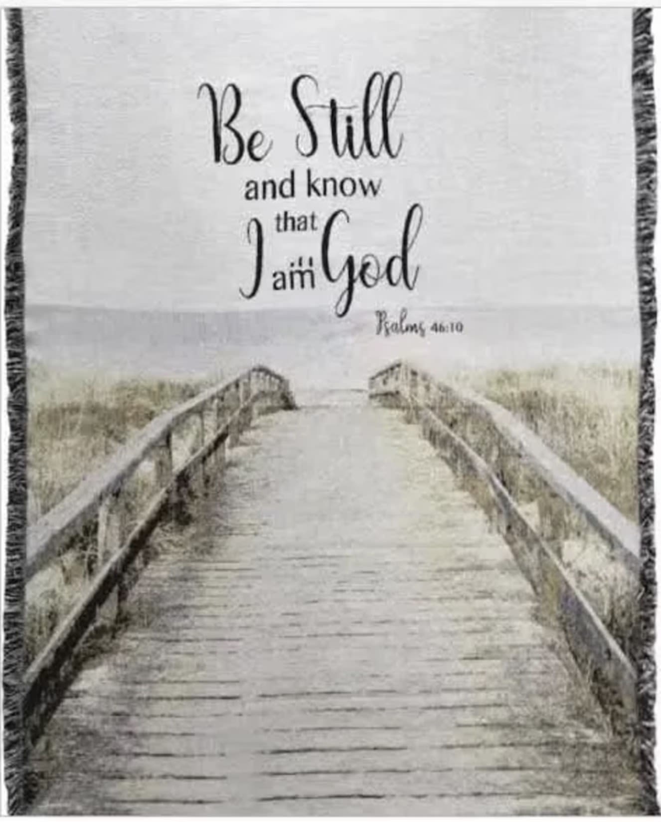 Be Still Woven Throw - Find comfort, faith, and meaningful beauty with our “Be Still and Know” woven keepsake throw collection. Featuring the comforting scripture from Psalm 46:10 and peaceful boardwalk artwork, these tapestry throws create a thoughtful gift for birthdays, encouragement, thinking of you, memorials, celebrations of life, church events, sympathy occasions, and everyday comfort.  Each throw may be ordered as a simple folded keepsake finished with a designer bow, displayed on a temporary easel for services and events, or upgraded with a fresh garden-style flower spray for an elegant presentation. Our floral designers style each display individually using fresh seasonal flowers and natural greenery to complement the artwork while maintaining a soft, realistic garden-inspired look.  Unlike ordinary gifts that are quickly forgotten, woven tapestry throws become lasting keepsakes that can be displayed in the home, draped across a chair, or wrapped around loved ones for years to come. The neutral tones and faith-inspired message make this design appropriate for both uplifting everyday gifting and meaningful memorial tributes.  Perfect for churches, funeral homes, hospitals, memorial services, birthdays, encouragement gifts, and celebration of life gatherings throughout Greensburg, Batesville, Shelbyville, Rushville, North Vernon, Columbus, and surrounding Indiana communities. Professionally designed and locally delivered with care.