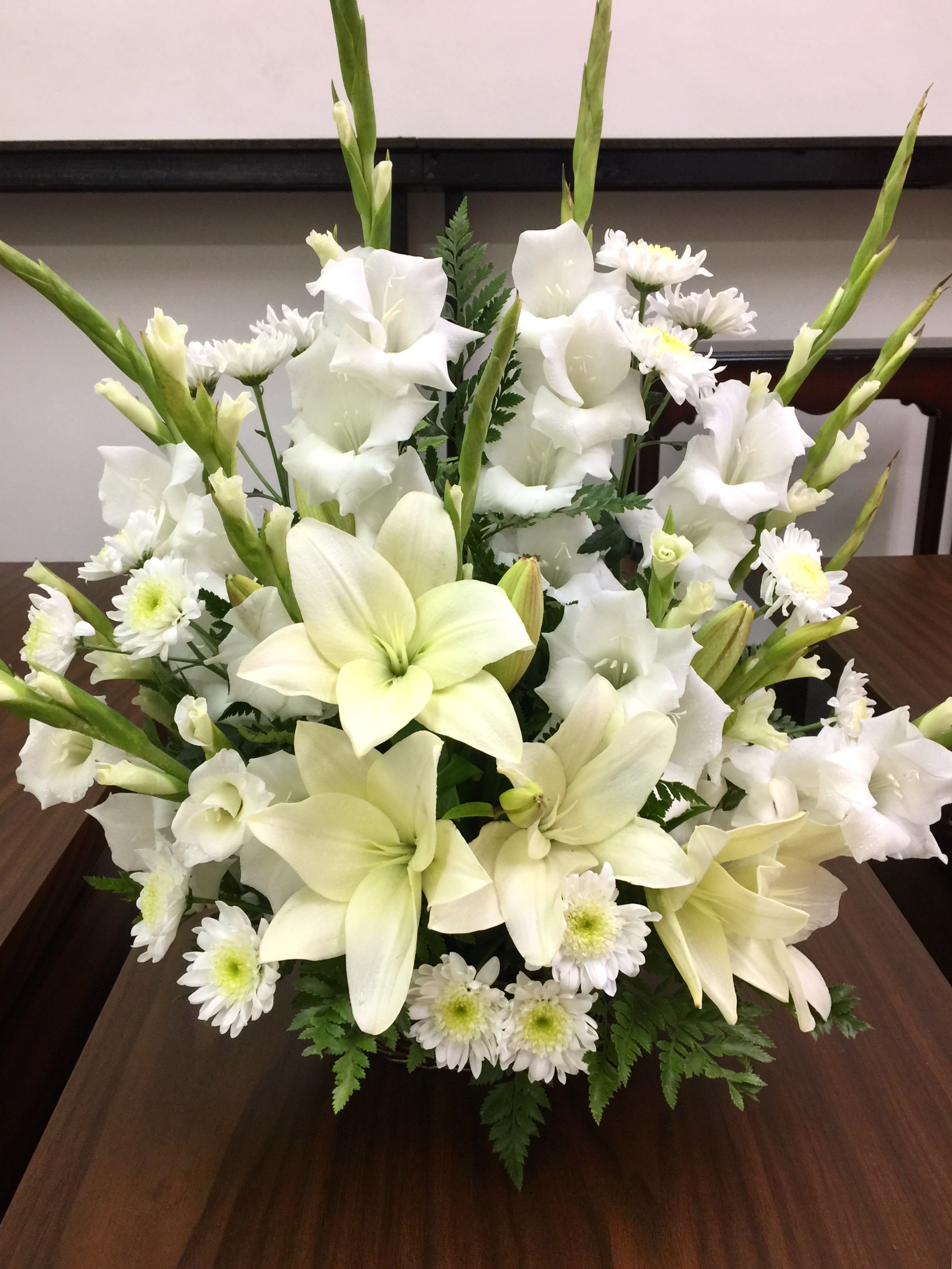 White lilies and daisies arranged in a low bouquet