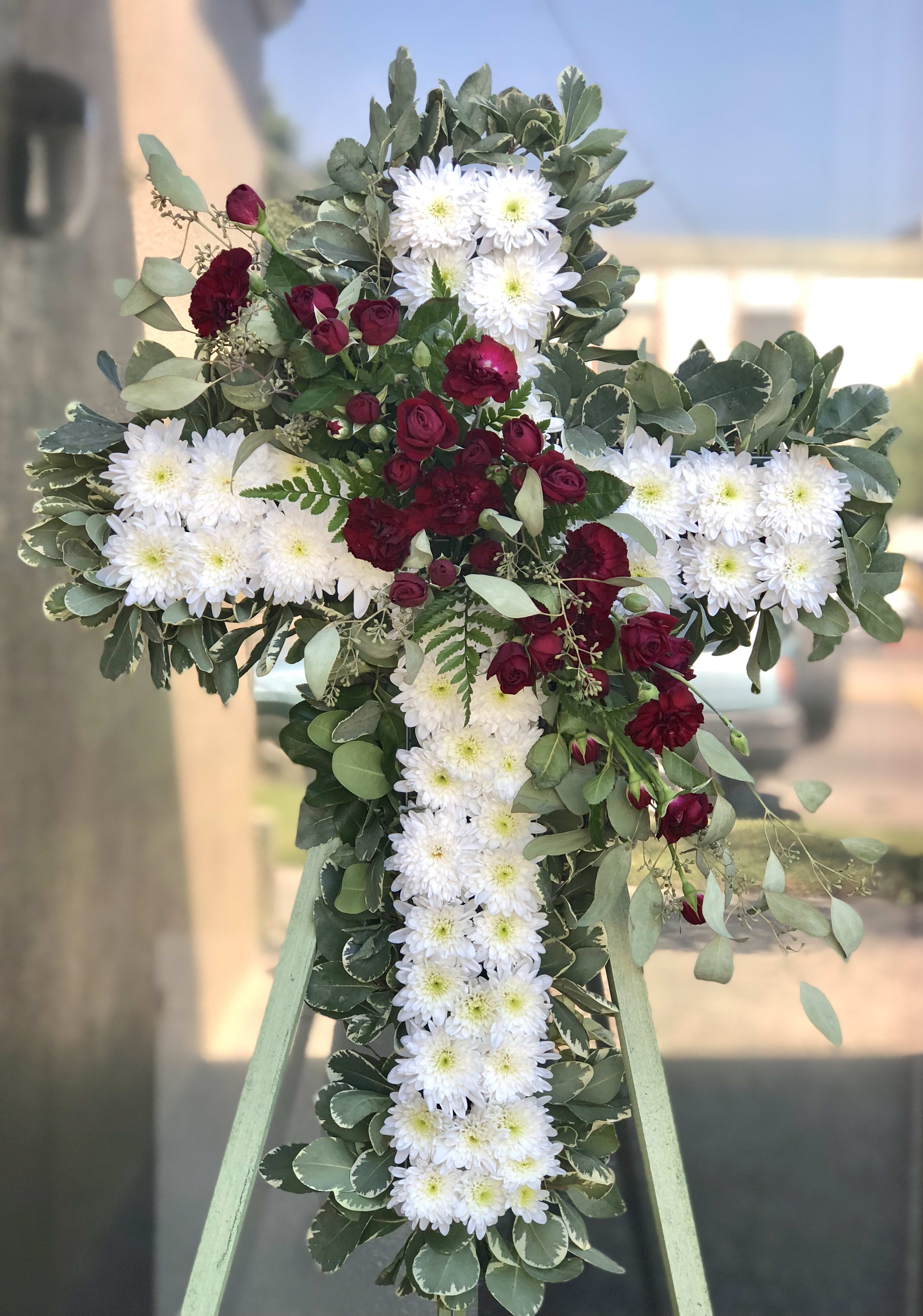 Cross-shaped floral tribute with white daisies and burgundy roses