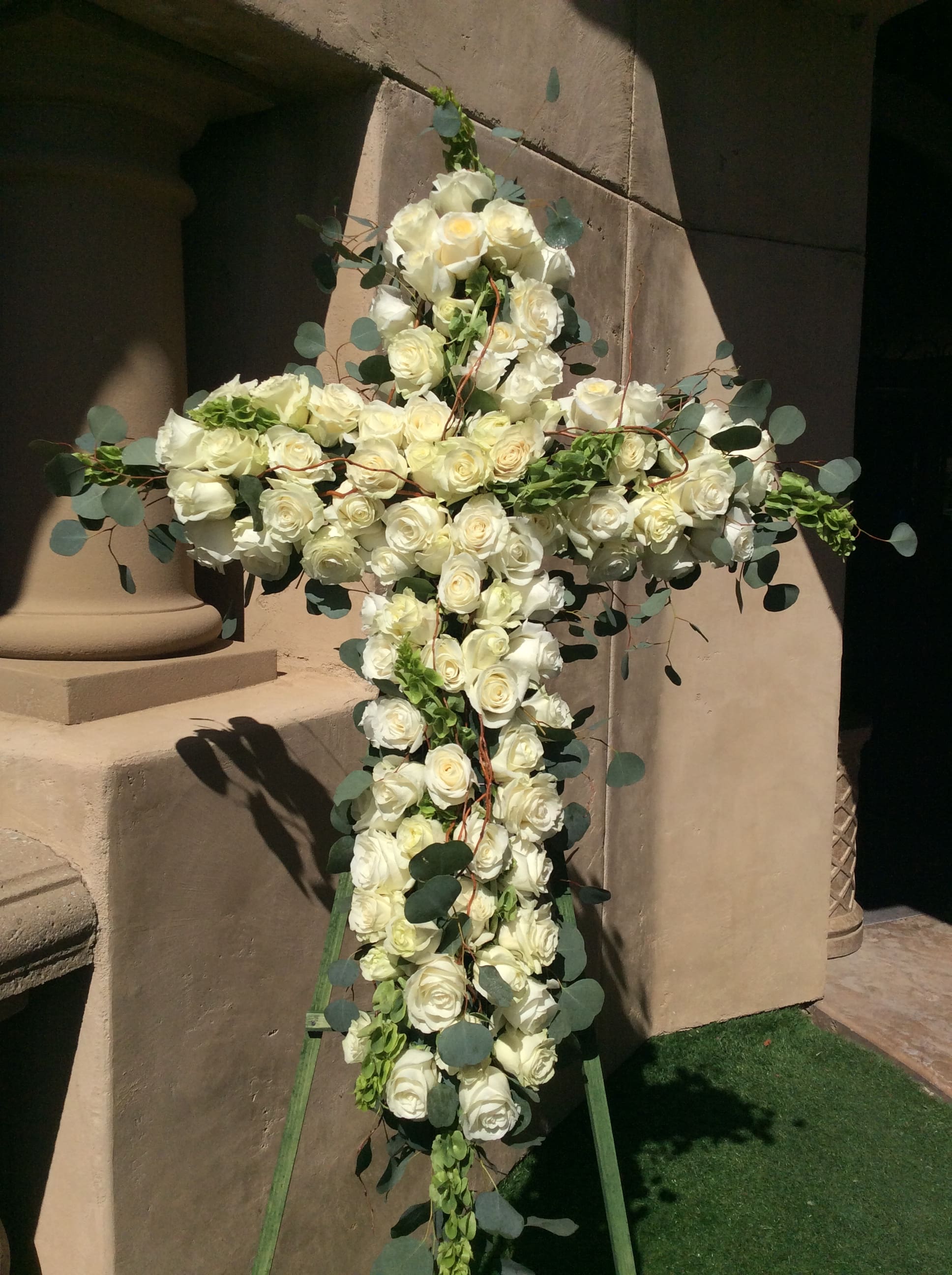 White rose cross arrangement with eucalyptus