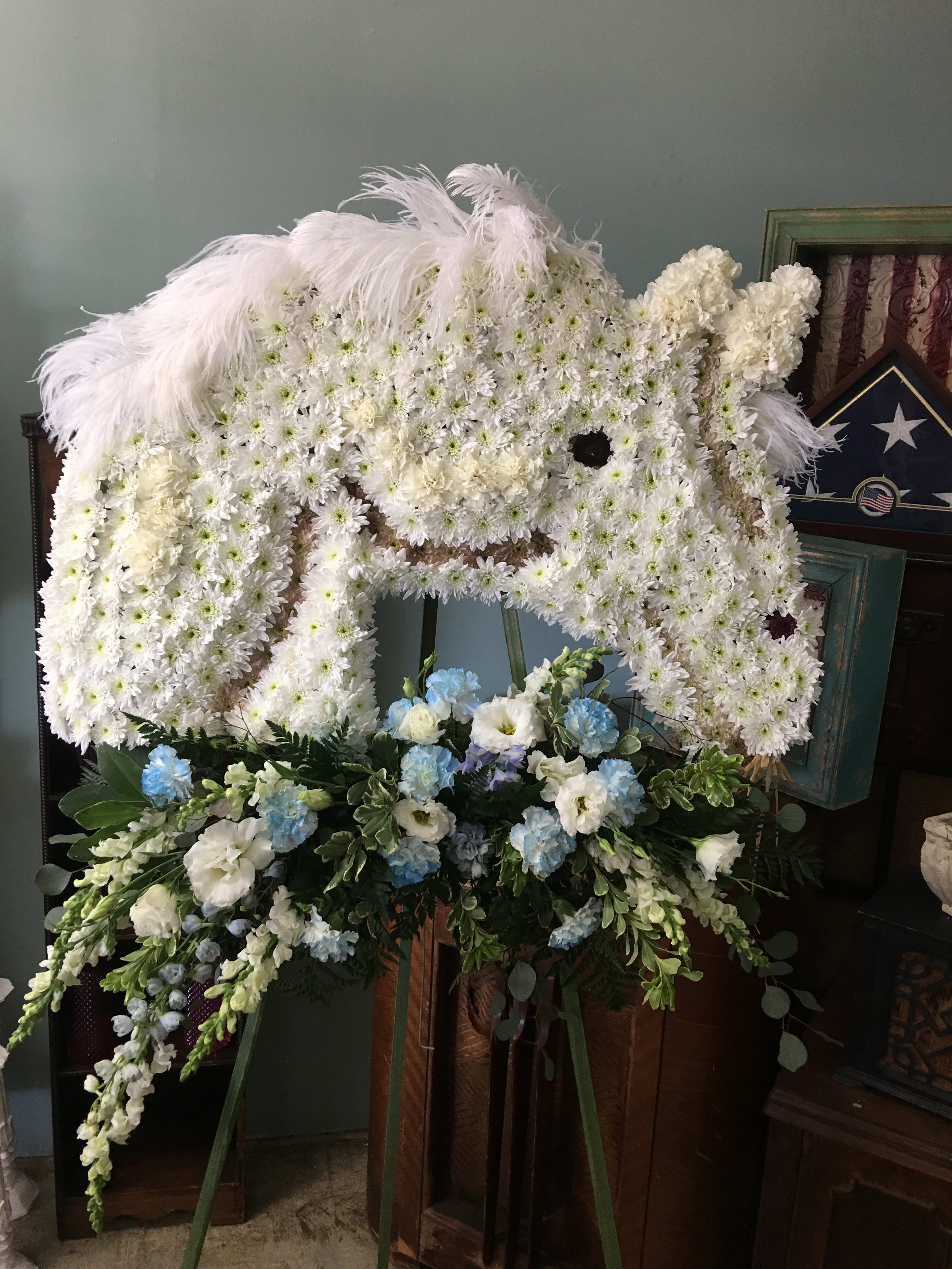 Celebration of Life  - 36" x 24" horse with cluster of flowers including white mums, carnations, snaps, roses, and mixed greens. 