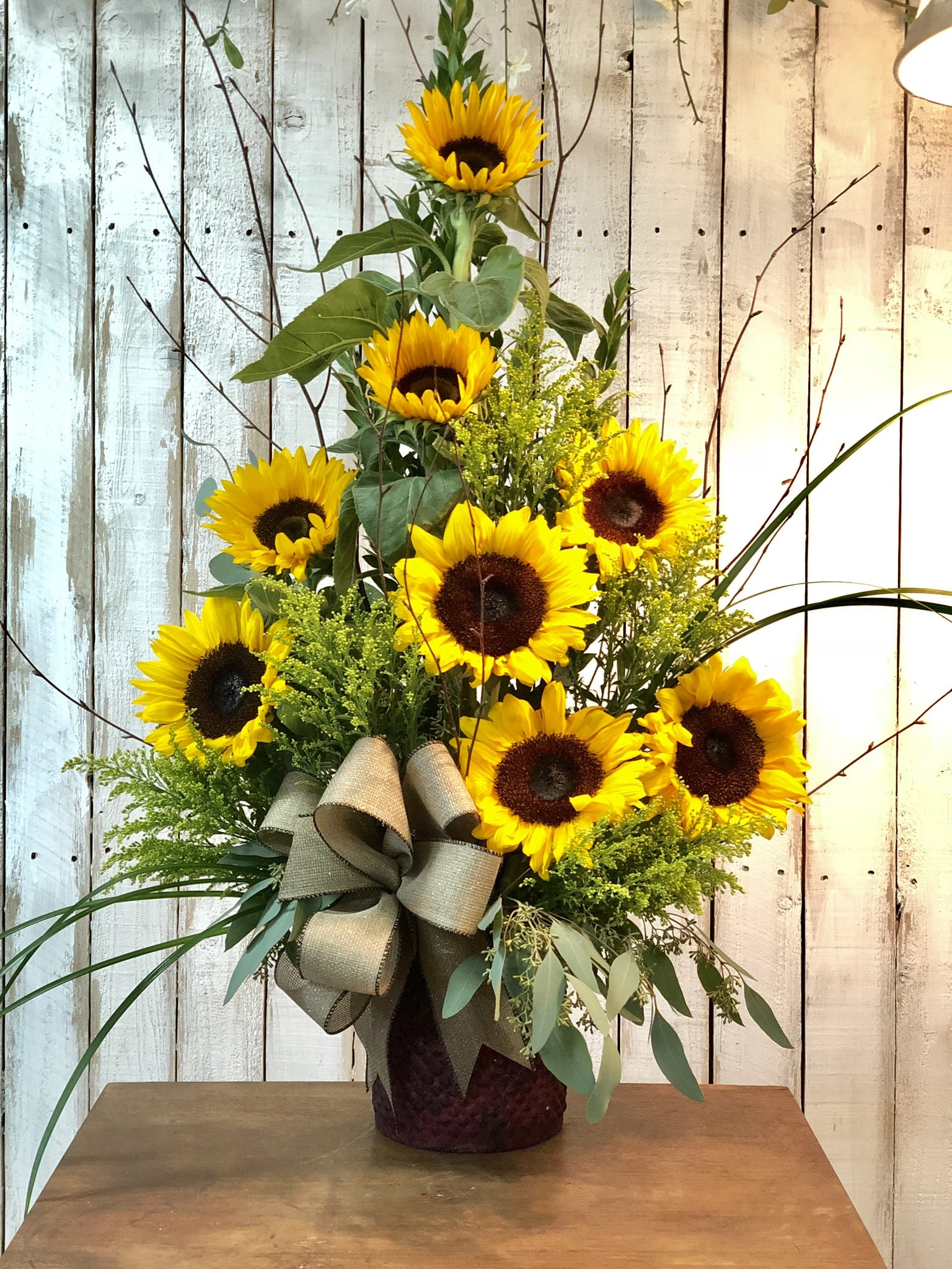 Burst of Sunshine  - Sunflowers and a variety of in season greens in a clear glass vase