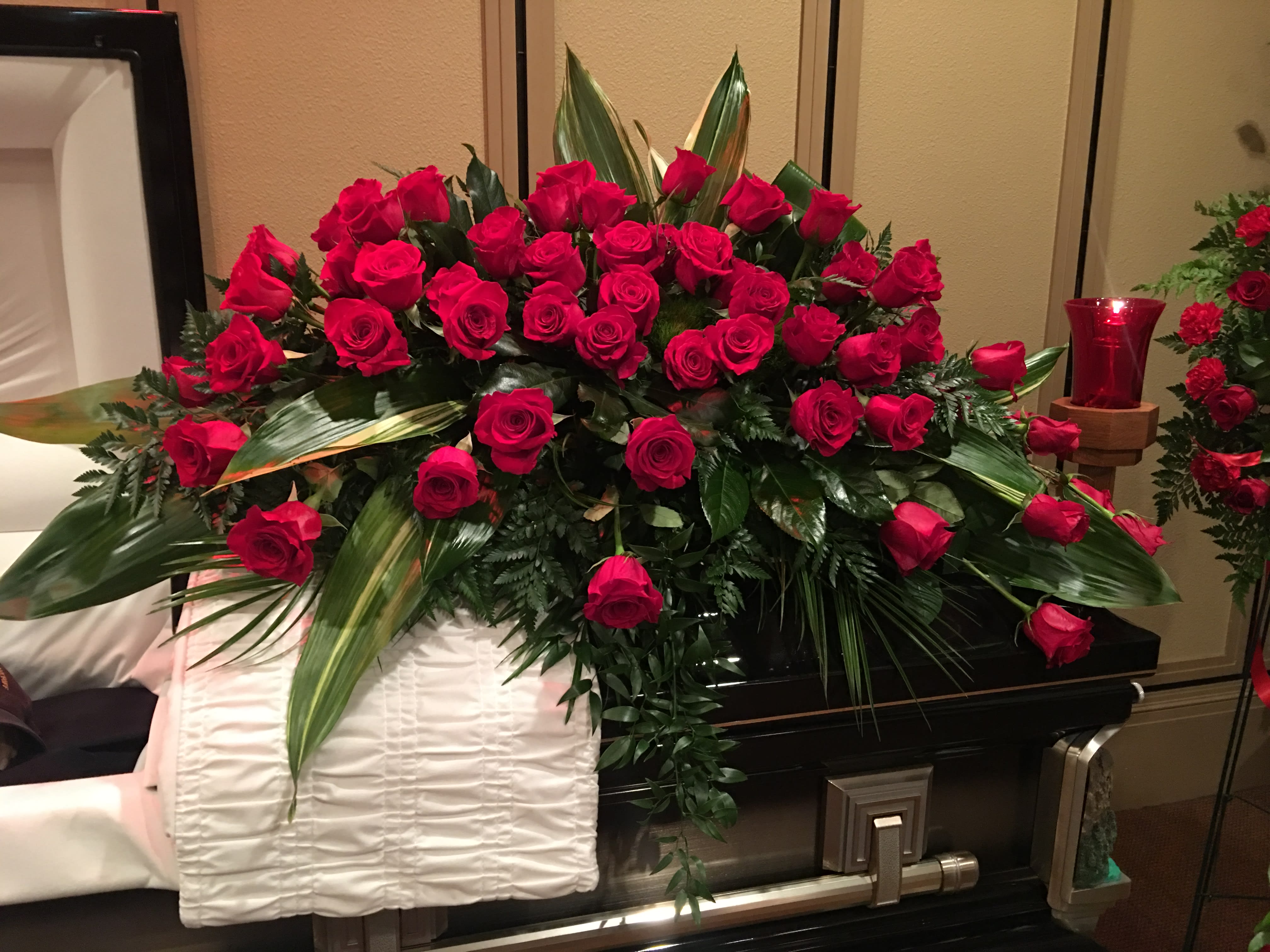 We love you  - Express your love and devotion with the traditional elegance of this stunning red rose casket spray. Ideal for a full couch or closed casket service, the impressive display features a generous array of bold, beautiful blooms.