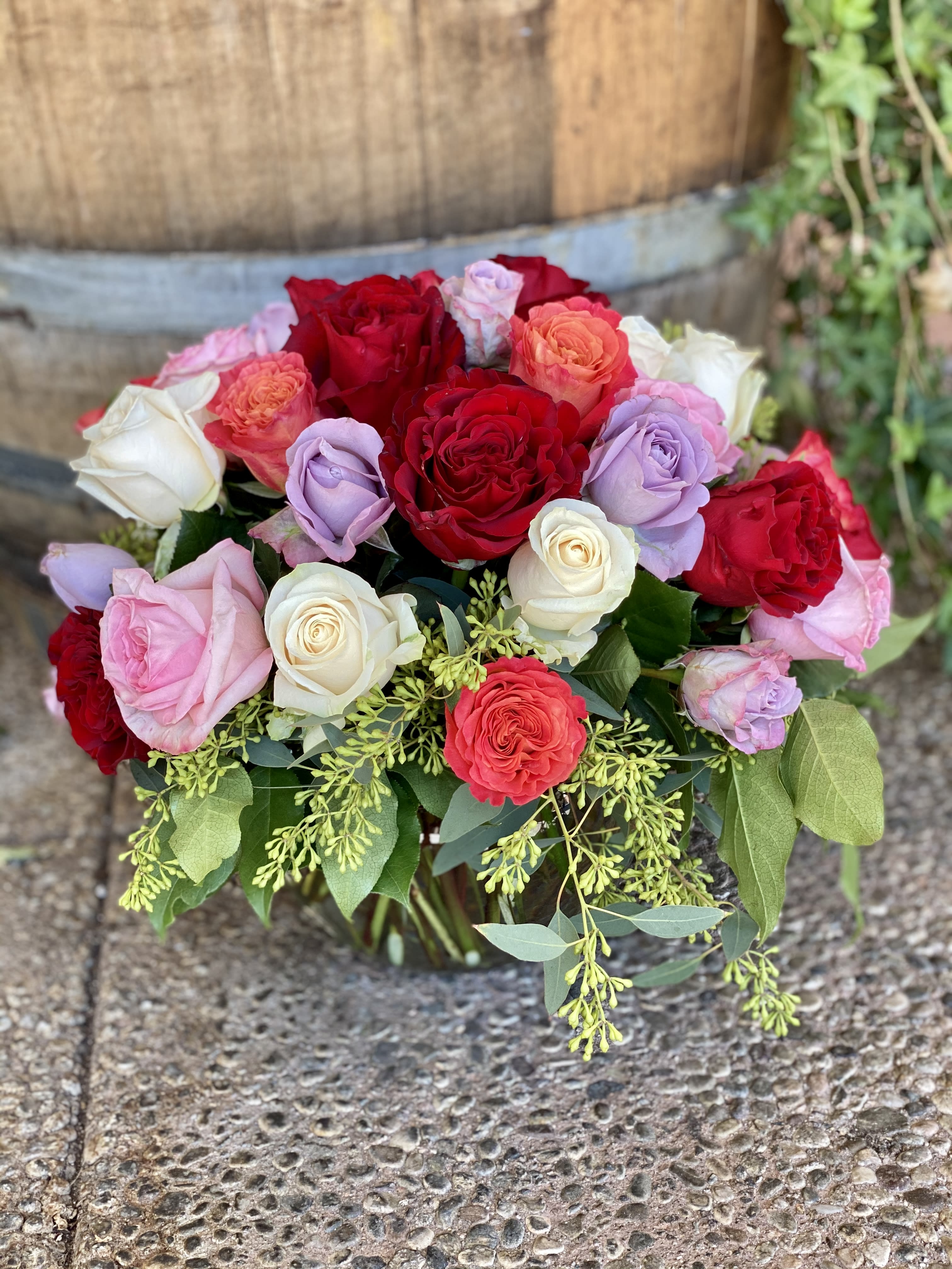 La Vie En Rose - A gorgeous compact arrangement of colorful roses and eucalyptus.