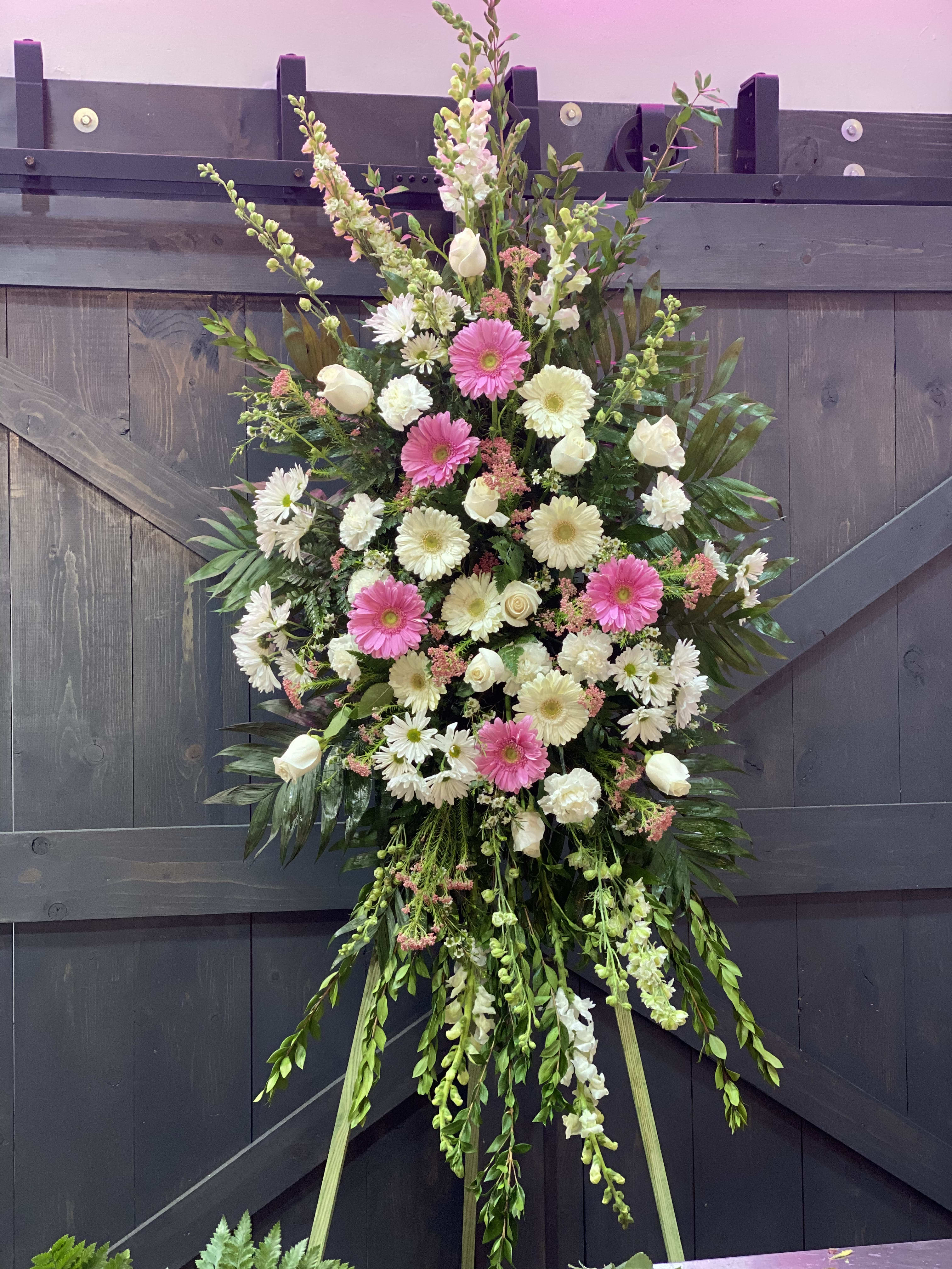 Love Lives On Spray - Includes soothing flowers such as white roses carnations cushion poms gladiolus and larkspur, plus pink daisies and babies breath 
