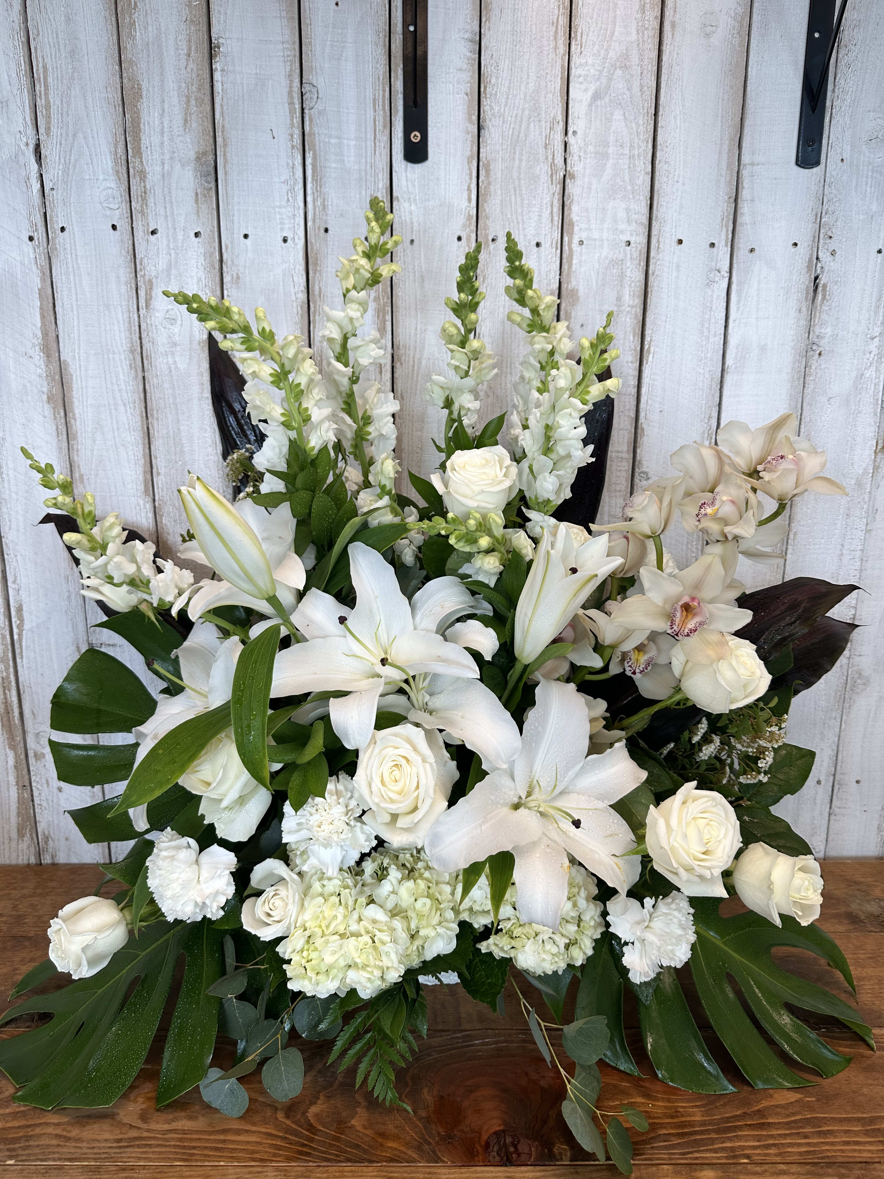 Our Beloved  - our beloved, This peaceful arrangement includes white hydrangea, white roses, white spray roses, white alstroemeria, gladiolas, stargazer, lilies white  eucalyptus 