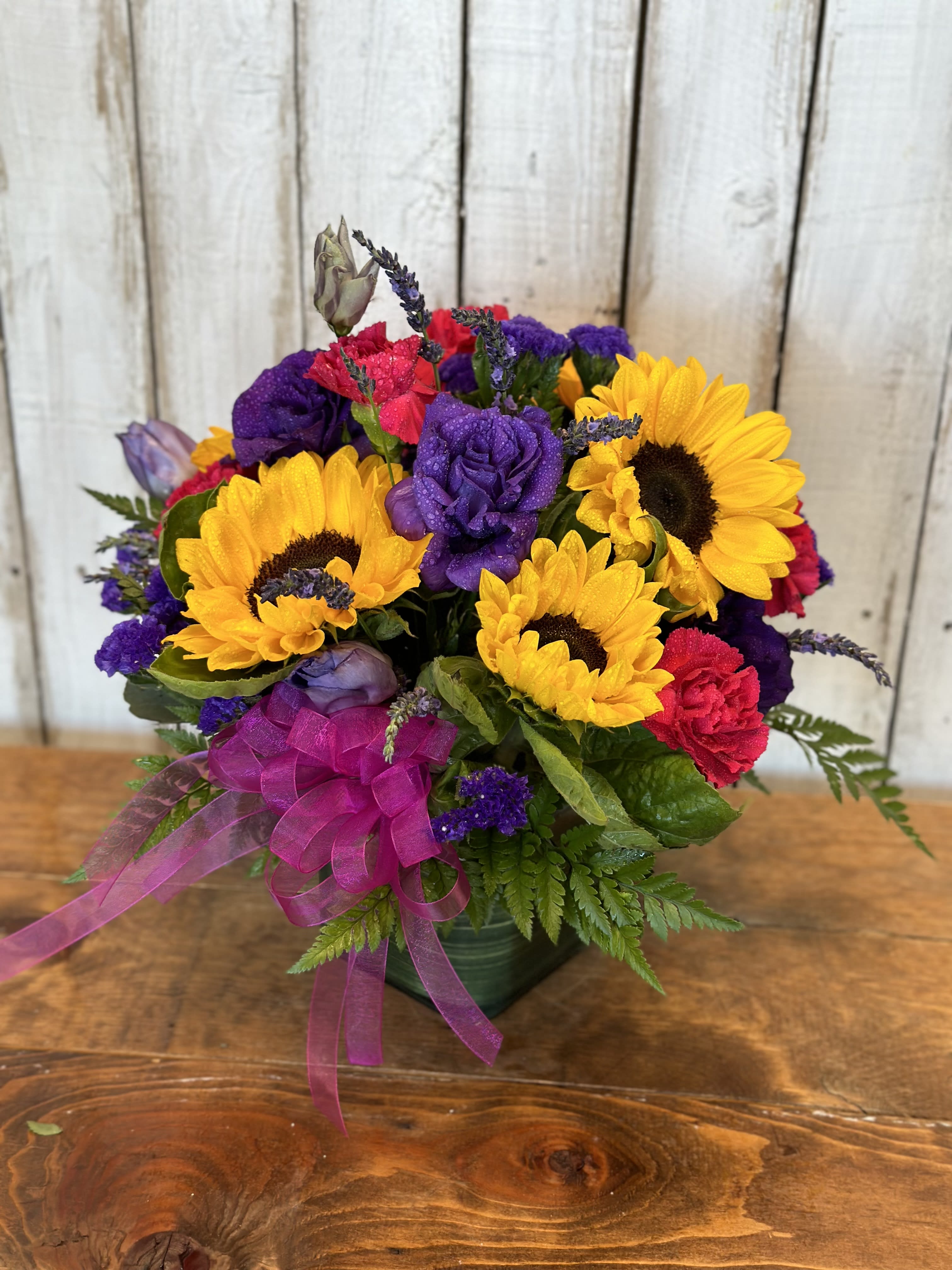 Only you  - This beautiful bouquet will make any gloomy day turn into a sunny day send a little sunshine today this beautiful arrangement consist of carnations sunflowers and purple status  with a beautiful, hot pink bow