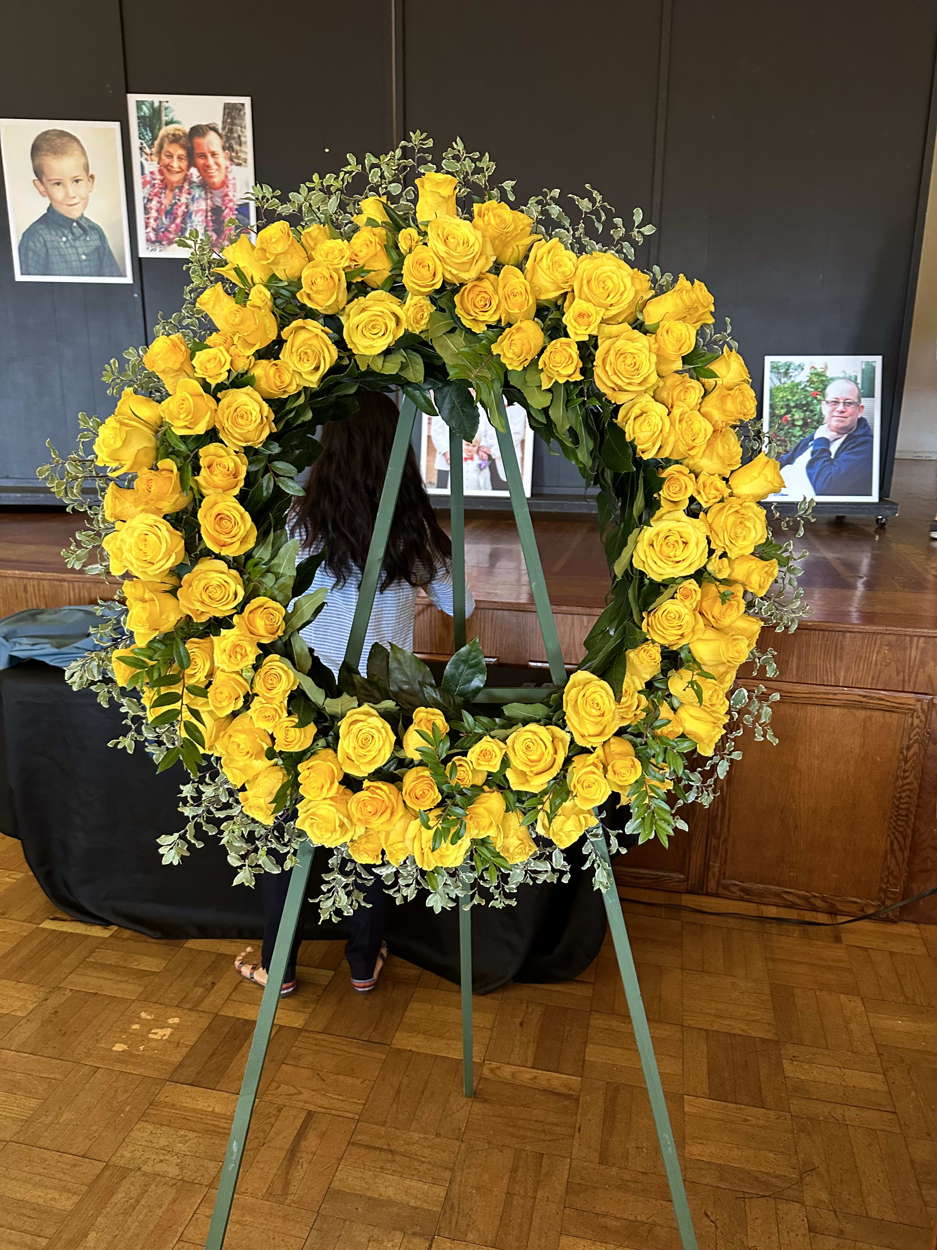 Large yellow rose funeral wreath on a standing easel