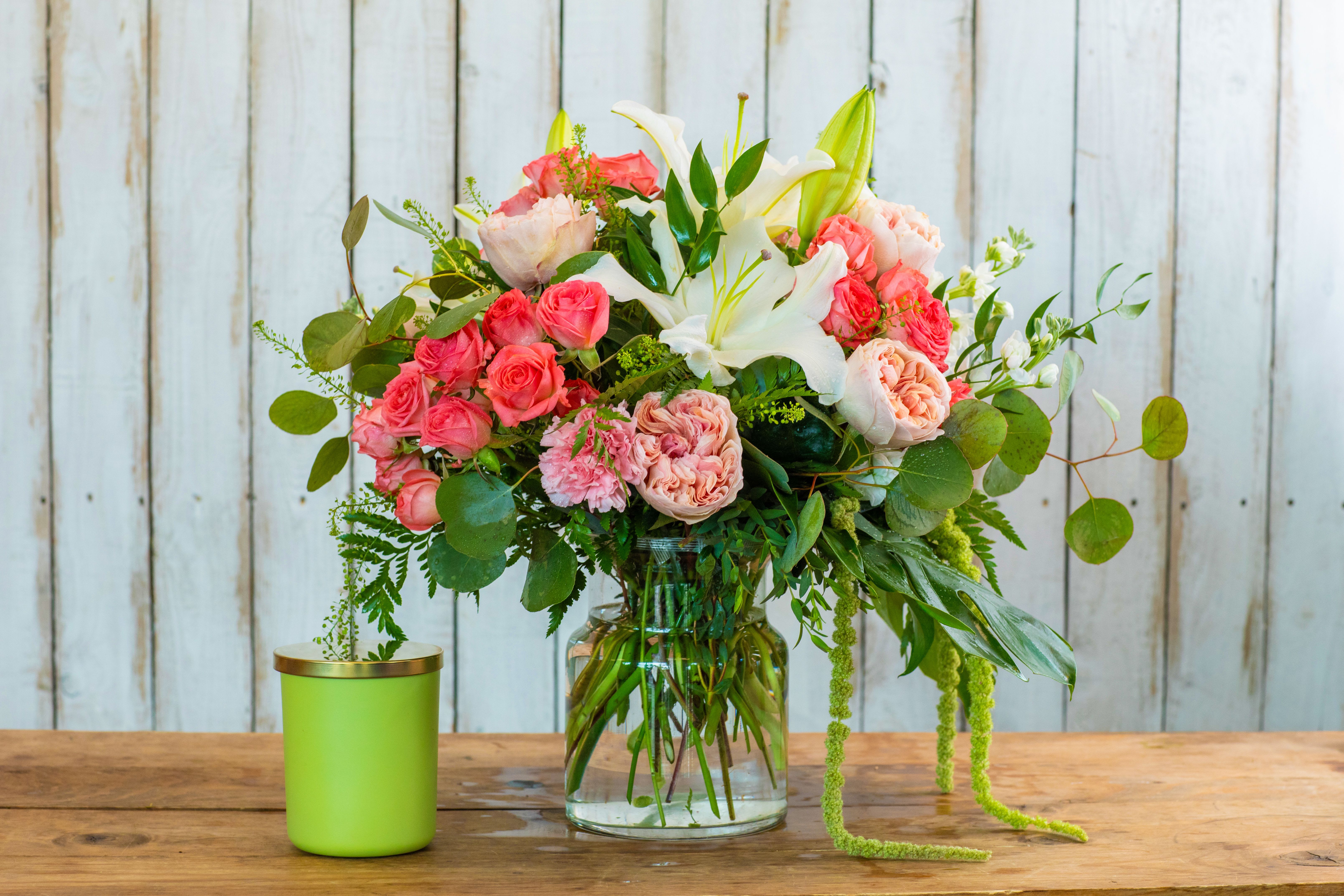 Rancho Romance Bouquet - Experience the fresh elegance of the Rancho Romance Bouquet, a truly stunning arrangement crafted by your local Rancho Cucamonga Florist. This exquisite display features a captivating blend of lush pink and coral roses, including beautiful garden roses, complemented by crisp white lilies. We've accented these magnificent blooms with vibrant greenery, including cascading amaranth and rounded eucalyptus leaves, creating a full and romantic presentation.  Perfect for any special occasion or just to brighten a day in the Rancho Cucamonga area, this bouquet is hand-arranged in a clear glass vase, showcasing the fresh stems. Whether you're searching for Mother's Day flowers, an unforgettable anniversary gift, a heartwarming birthday bouquet, or thoughtful sympathy flowers, this arrangement is a perfect choice.  As the leading Rancho Cucamonga flower shop, we offer reliable same-day flower delivery throughout the region. Trust our expertise to deliver farm-fresh flowers straight to your door. Order this gorgeous floral arrangement online today from your dedicated Rancho Cucamonga Florist!