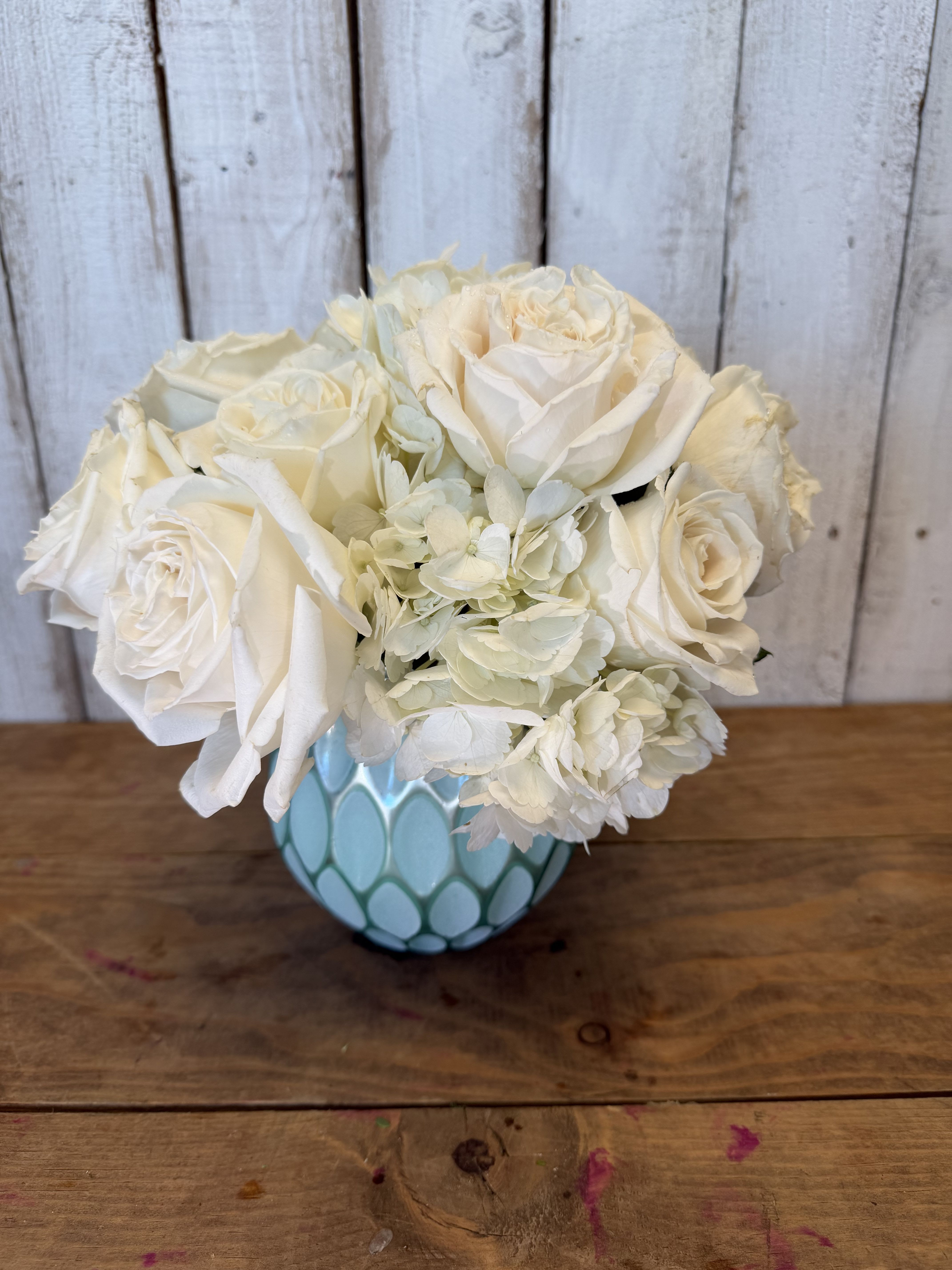 condolences  - Elegant and stylish, this monochromatic white rose bouquet is elevated by a frosted glass vase featuring a sculpted design and a shimmering faux mercury glass finish.Keepsake container  White hydrangea and gorgeous white playablonca roses
