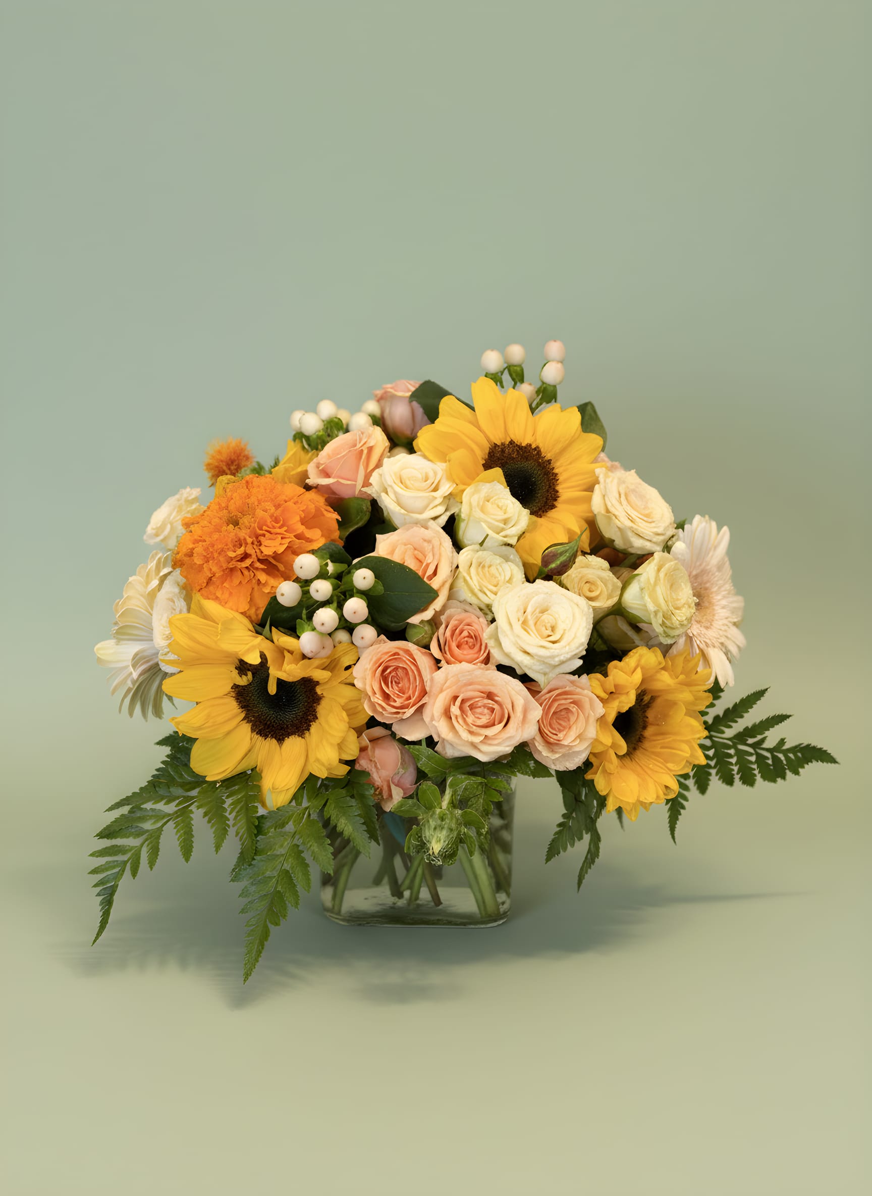 Sunshine &amp; Sweetness™ - Brighten someone’s day with our cheerful Sunshine &amp; Sweetness™ floral arrangement. This joyful design features radiant sunflowers, premium peach spray roses, creamy white roses, gerbera daisies, seasonal blooms, and lush greenery arranged in a clear glass vase.  Designed to capture the warmth of sunshine and the beauty of a blooming garden, this arrangement is perfect for birthdays, congratulations, get well wishes, thank-you gifts, new beginnings, and everyday celebrations. The combination of sunny yellow, soft peach, and creamy white creates a fresh and uplifting design that instantly brings happiness to any room.  Handcrafted by Tommy Austin Florist, each arrangement is designed with premium flowers and artistic attention to detail, making it a memorable gift for family, friends, coworkers, and loved ones.  Perfect For   Birthday Flowers Get Well FlowersCongratulations Gifts Thank You Flowers New Home Celebrations Thinking of You Gifts  Just Because Flowers