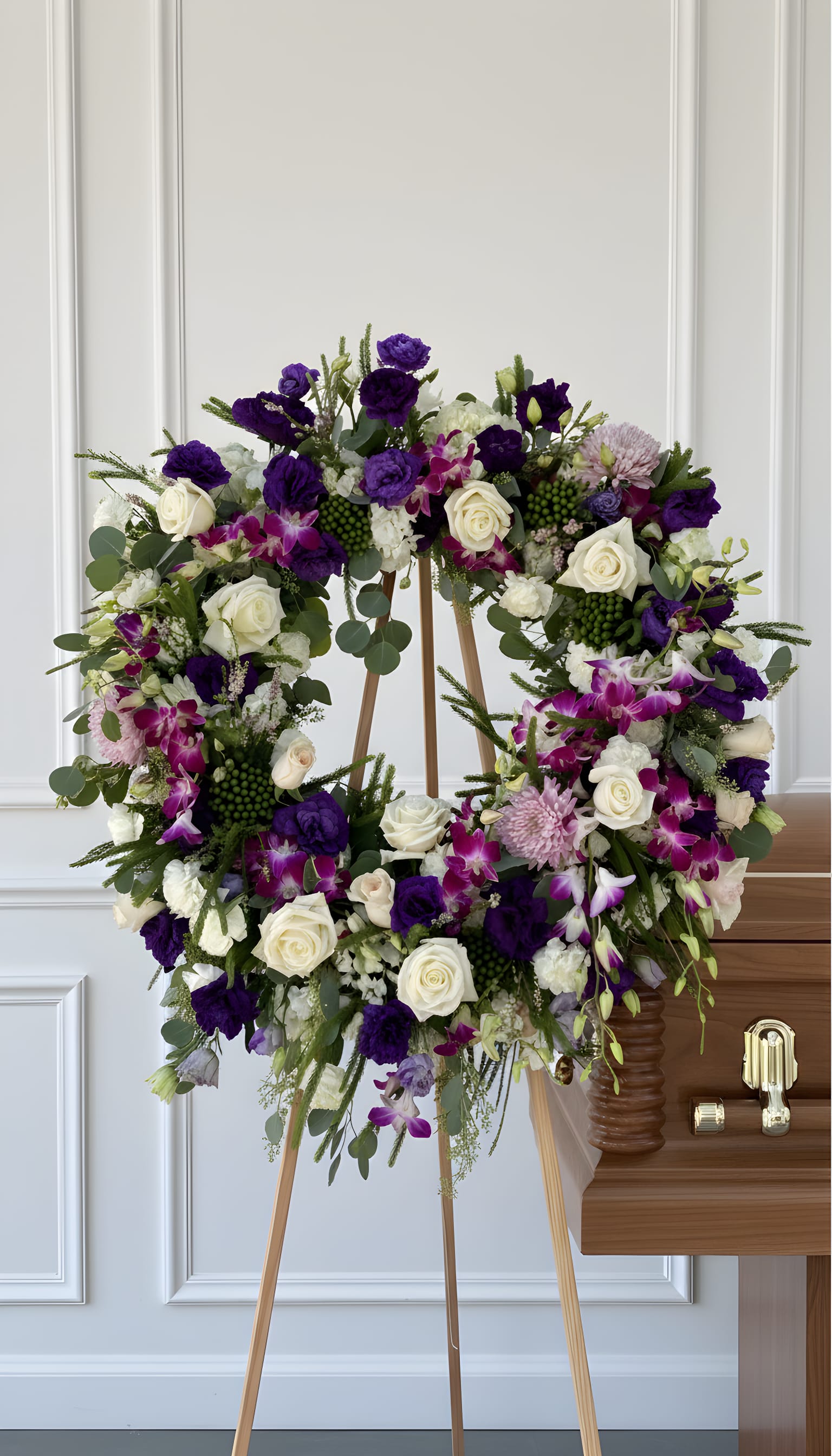 Lavender Legacy™ - Honor a cherished life with our Lavender Legacy™ sympathy wreath. This luxurious standing tribute features premium white roses, vibrant purple orchids, lisianthus, chrysanthemums, and fresh seasonal greenery artfully arranged in a timeless circular design. Symbolizing eternal love and remembrance, this elegant wreath offers comfort, beauty, and heartfelt condolences during life’s most meaningful moments. Handcrafted by Tommy Austin Florist, the Lavender Legacy™ is a graceful choice for funeral services, memorial gatherings, celebration of life ceremonies, and sympathy tributes.  A beautiful circle of love, remembrance, and everlasting grace. 