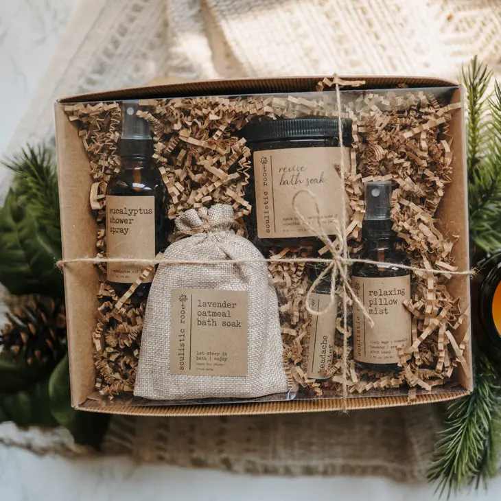Gift box with bath products and a fabric pouch on shredded paper
