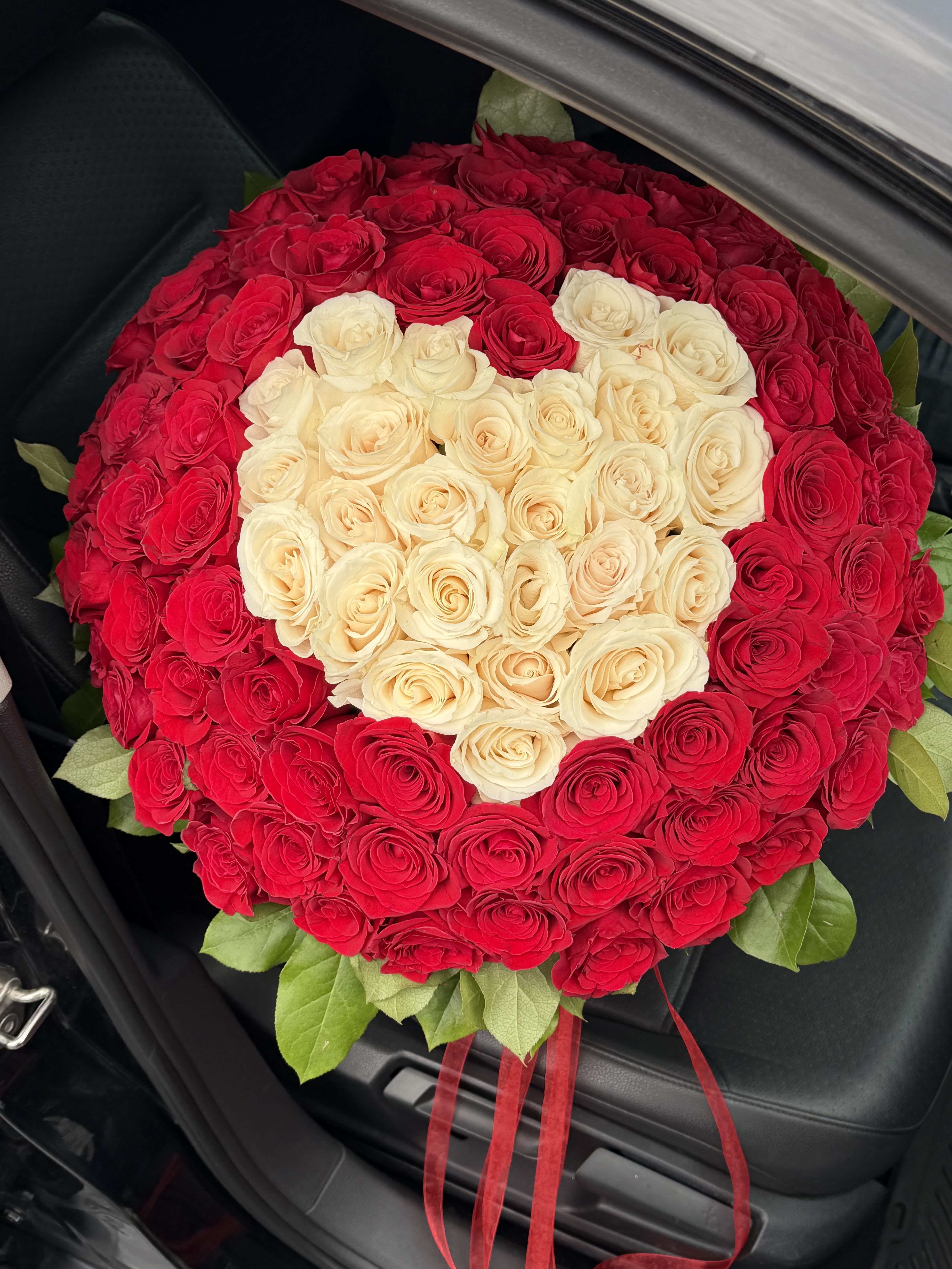 Heart of Devotion - Heart of Devotion is more than a bouquet — it is a powerful expression of love, commitment, and deep emotion.  This breathtaking heart-shaped arrangement is handcrafted from premium, long-stem roses, carefully selected for their freshness, rich color, and flawless petals. Each rose is placed by hand to create a perfectly sculpted heart — a universal symbol of love that speaks without words.  Designed for life’s most meaningful moments, Heart of Devotion is the ultimate gift when you want to make a lasting impression. Whether it’s an anniversary, proposal, birthday, Valentine’s Day, or a once-in-a-lifetime surprise, this bouquet delivers an unforgettable emotional impact.  Every arrangement is created by a professional local florist and delivered fresh on your selected date. While exact rose shades may vary slightly depending on availability, the overall style, shape, and luxurious feel of the bouquet are always preserved to meet our highest standards.