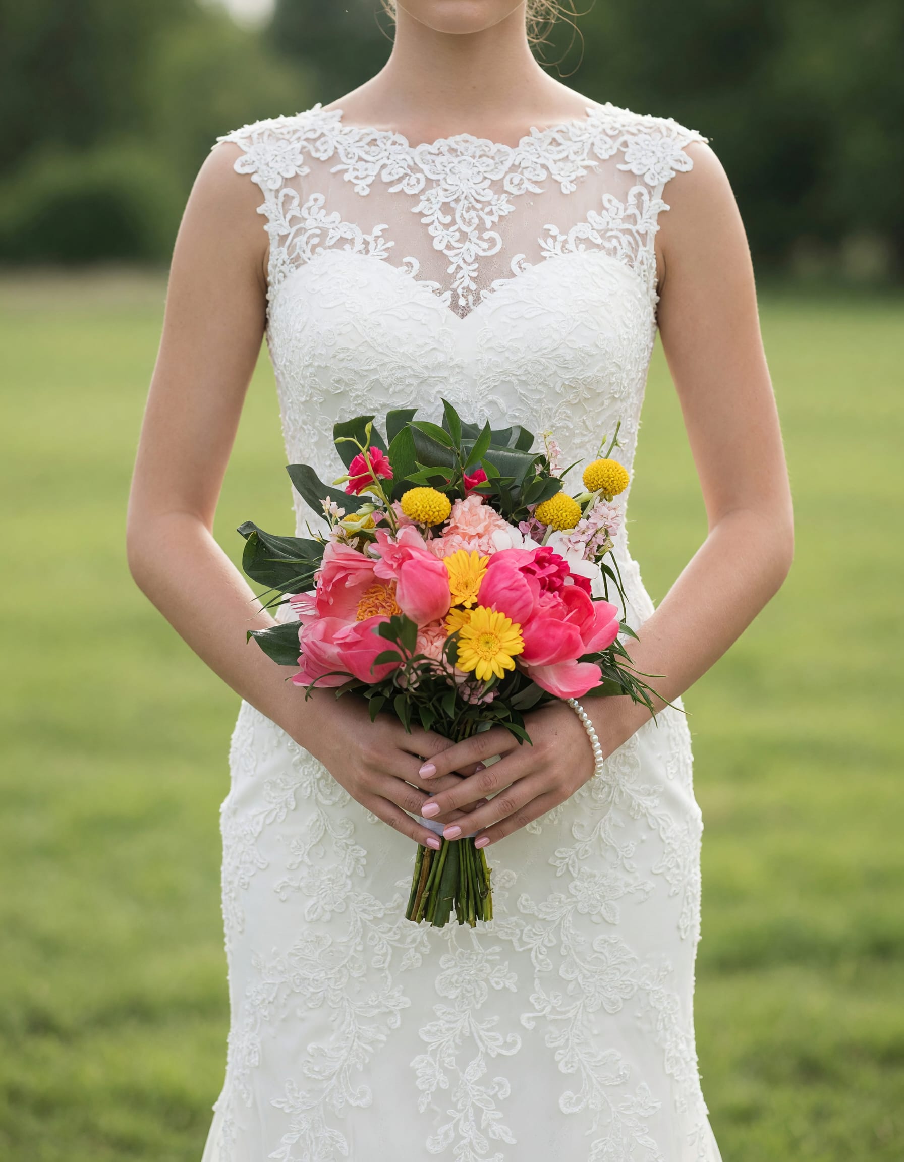 Bride holding a colorful bouquet of pink and yellow flowers