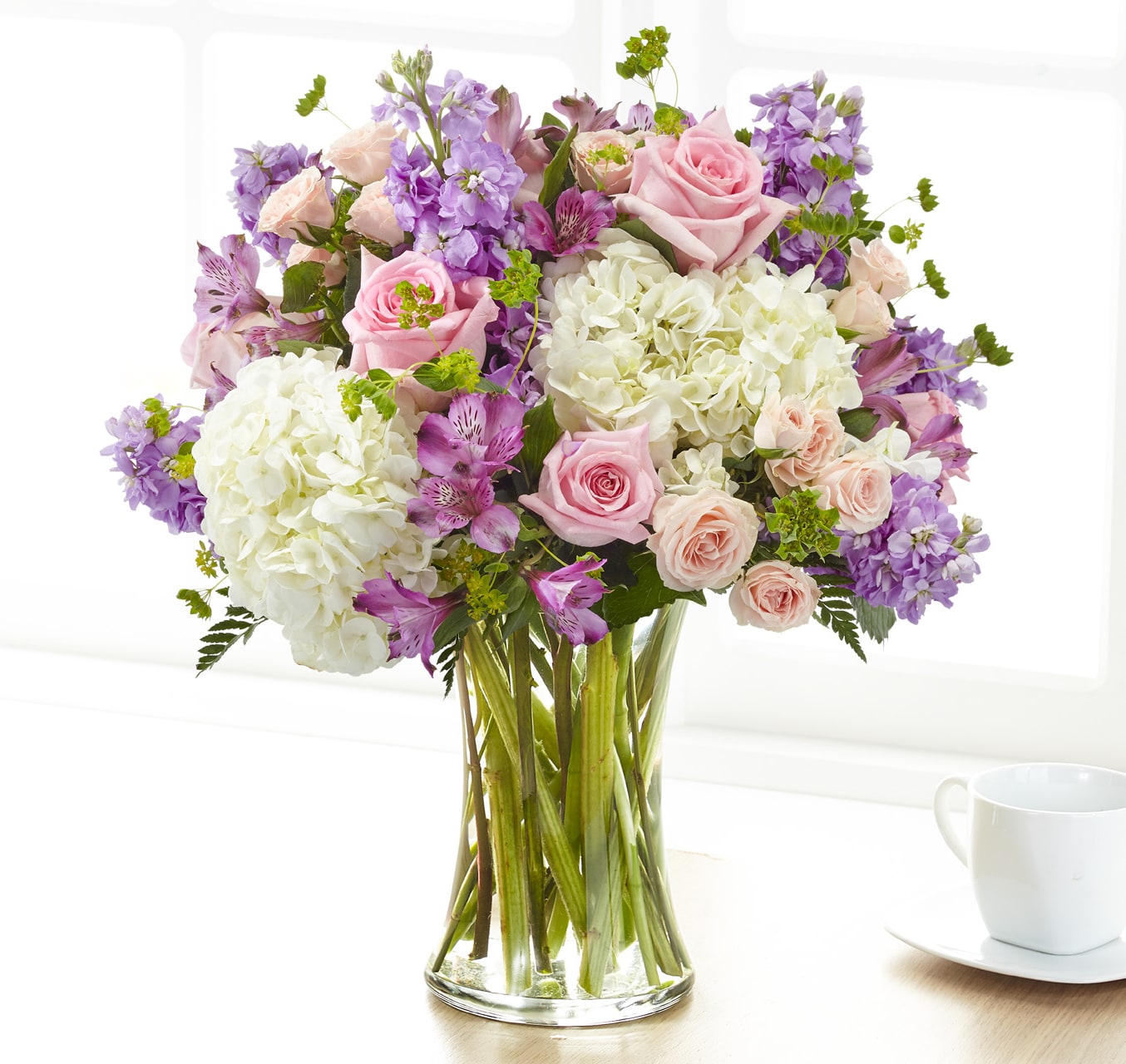 Pink roses and white hydrangeas in a clear glass vase