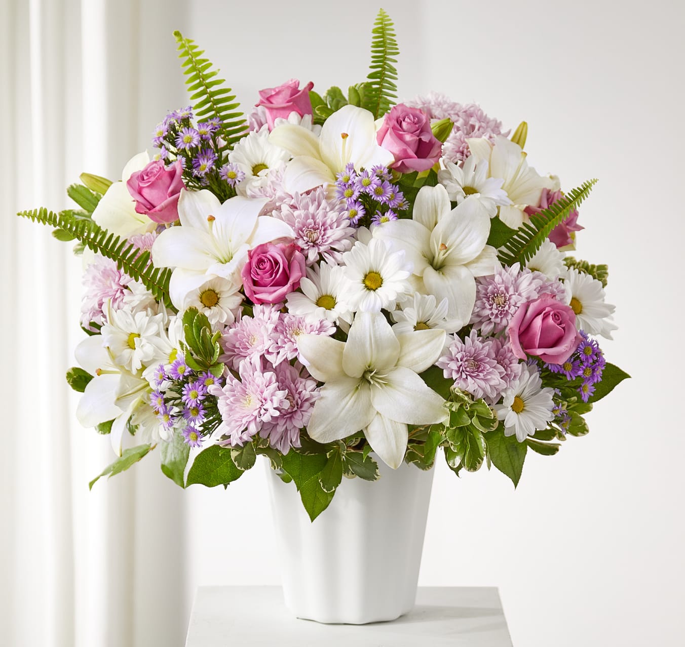 Pink roses and white lilies in a white vase