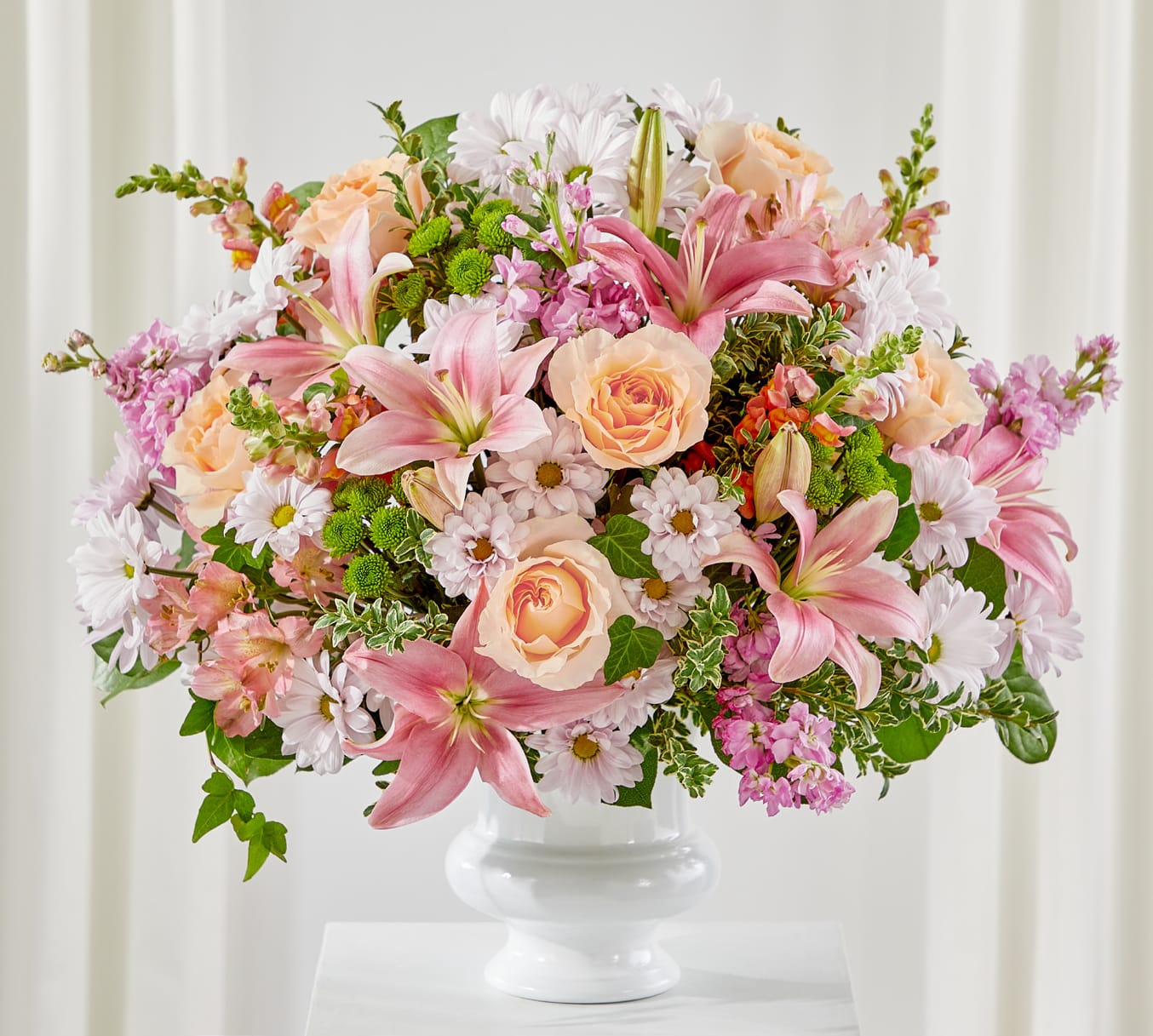 Pink lilies and peach roses in a white vase