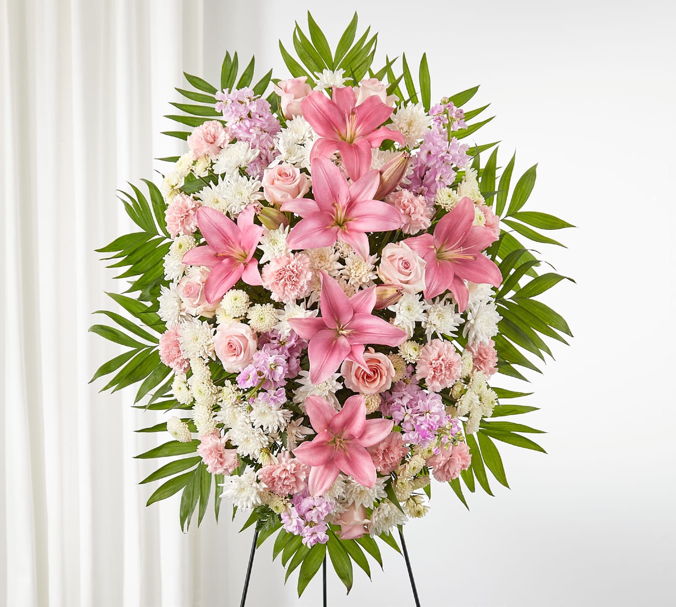 Pink and white floral standing spray on a black easel